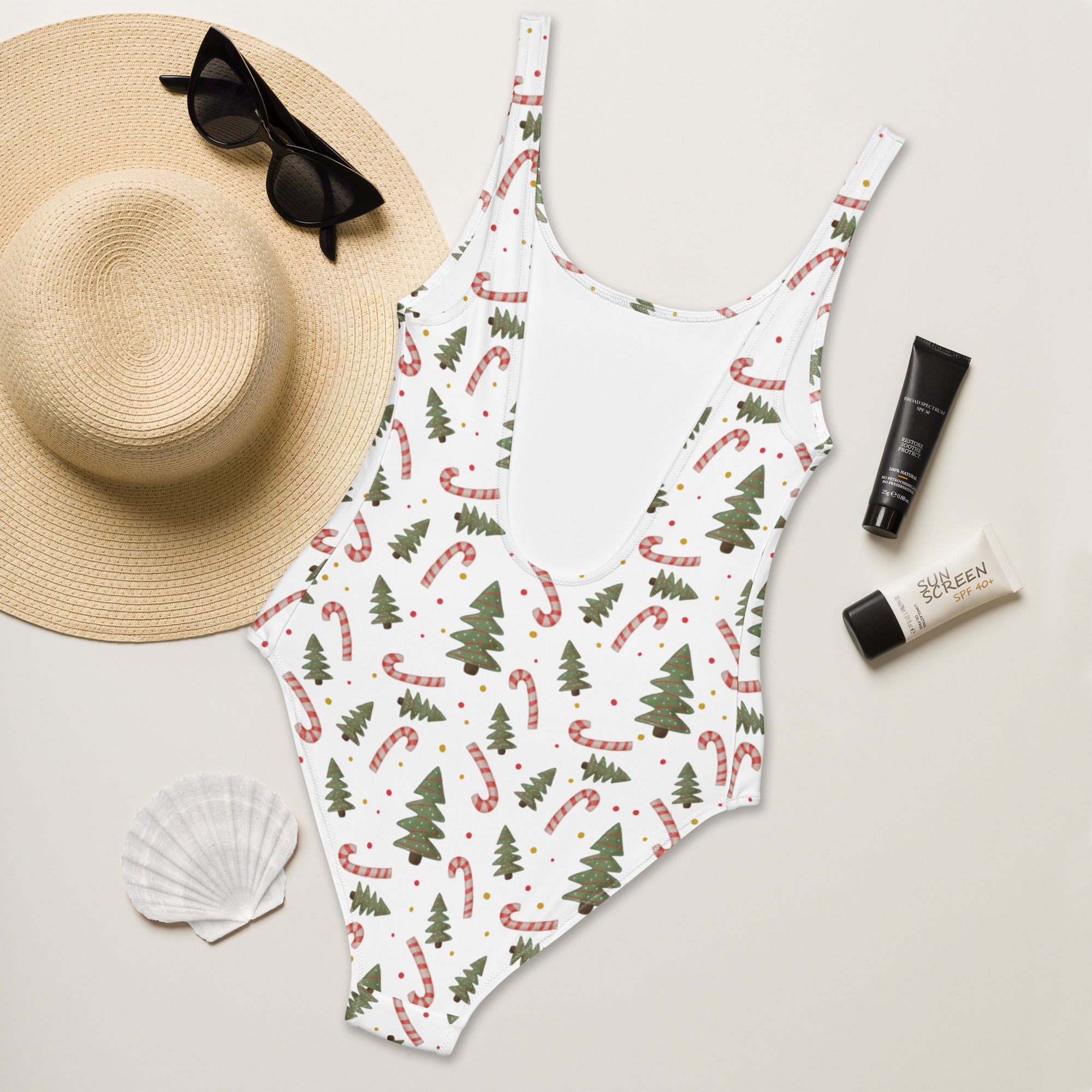 White one-piece swimsuit with buttery soft fabric featuring festive green pine trees and red and white candy canes with upf 50+