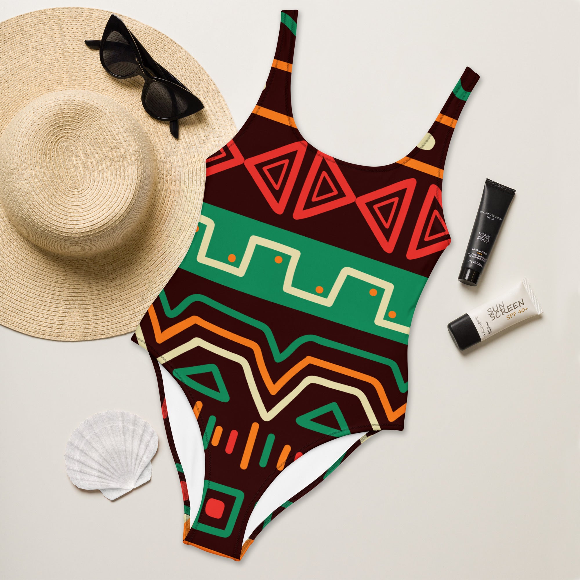 Women’s african-inspired tribal print one-piece swimsuit with bold red green orange and brown geometric pattern and UPF 50+