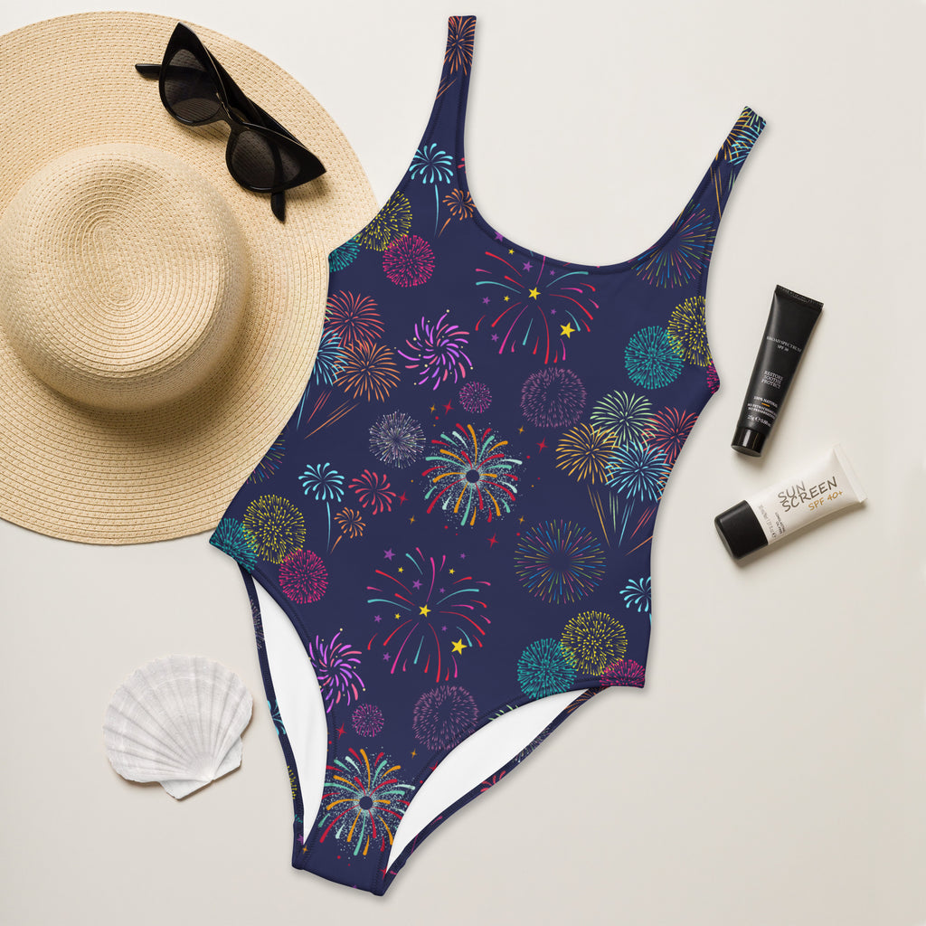 A navy blue one-piece swimsuit with a vibrant multicolored fireworks pattern made of buttery soft fabric with UPF 50+