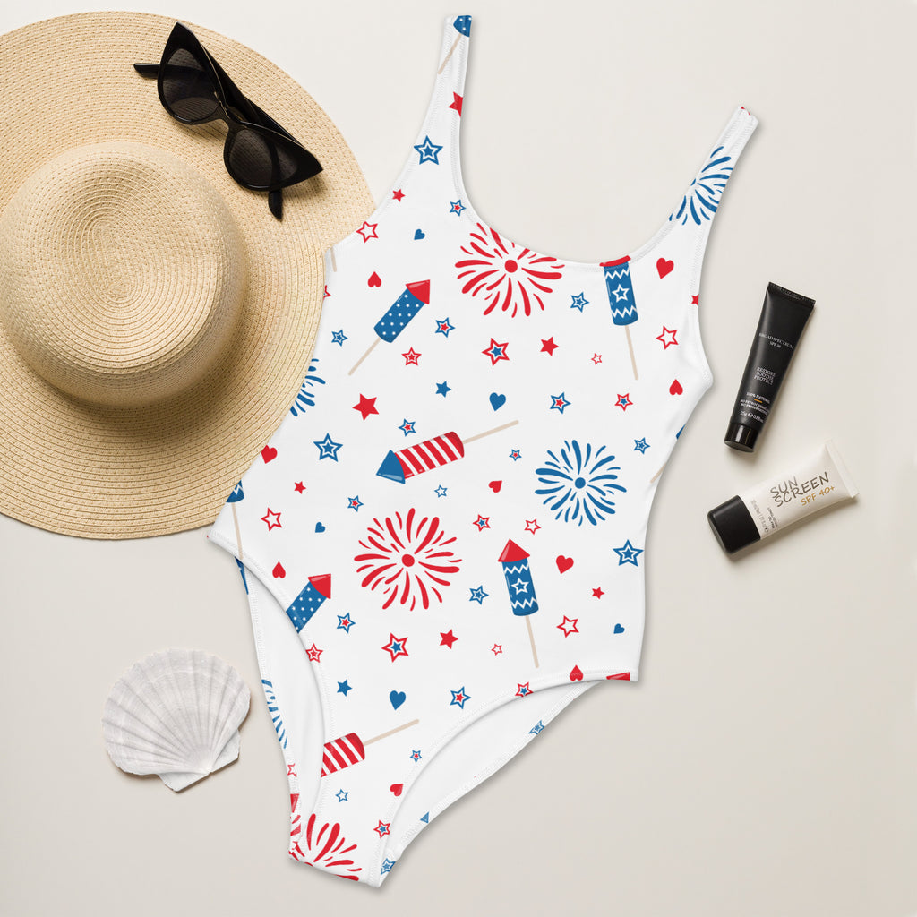 White buttery soft one-piece swimsuit with red blue fireworks stars hearts print and UPF 50 plus for 4th of July