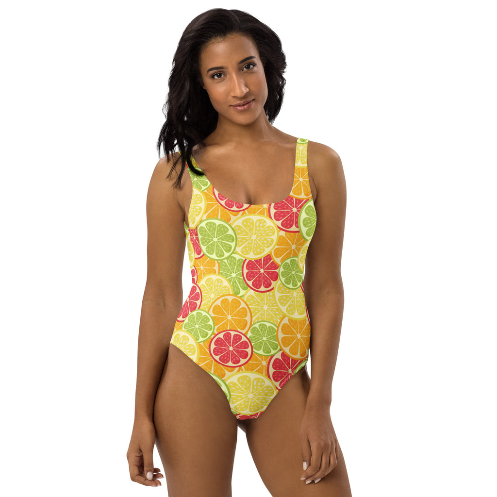A vibrant one-piece women’s citrus fruit slices buttery soft swimsuit in yellow green and pink with UPF 50 plus protection