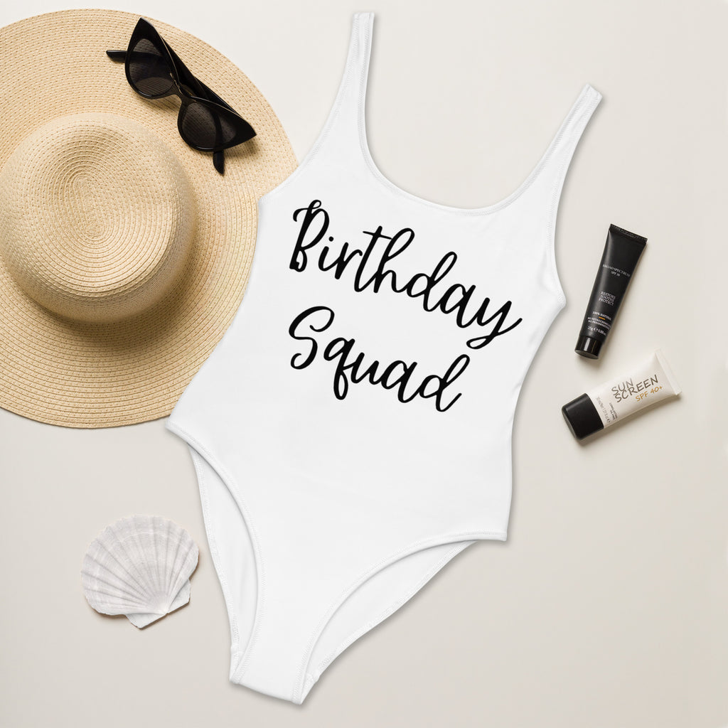 White buttery soft one-piece swimsuit with birthday squad print in black cursive script and upf 50 plus protection