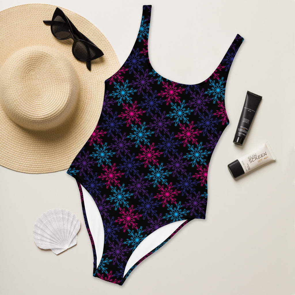 Women’s neon snowflake christmas buttery soft swimsuit with upf 50+ black base and colorful glowing snowflake patterns