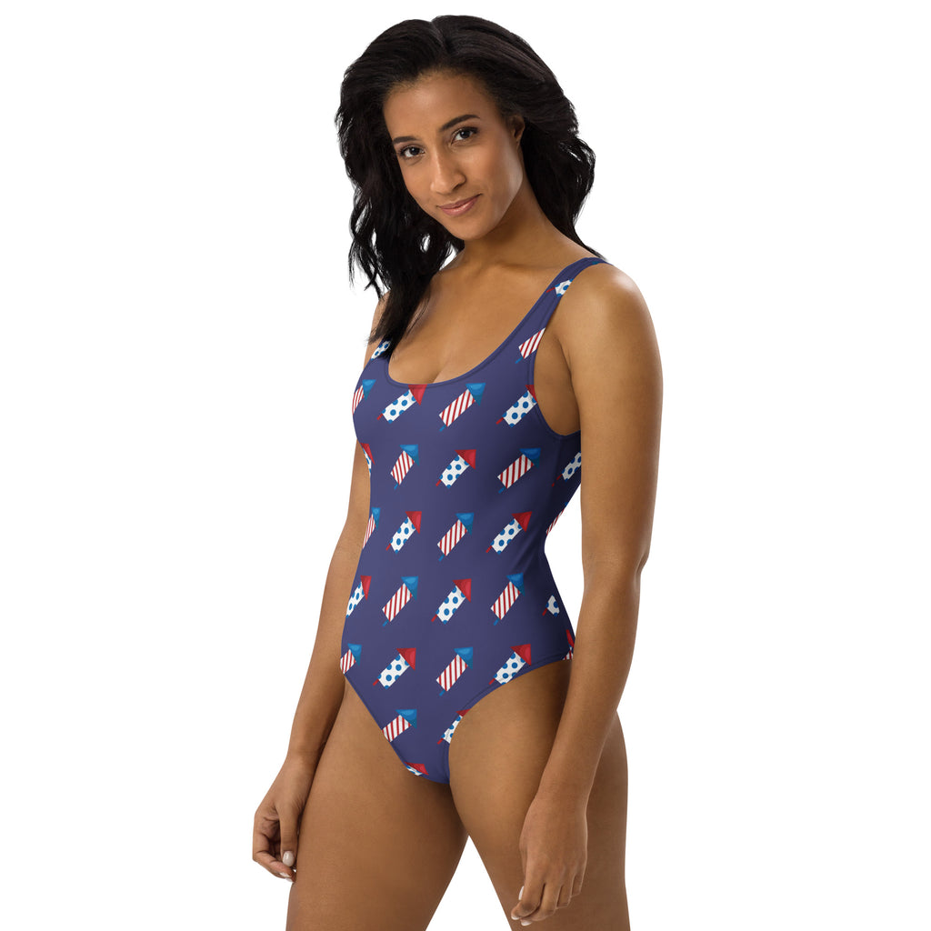 Women’s navy blue buttery soft one-piece swimsuit with red white and blue firework rockets and UPF 50 plus protection