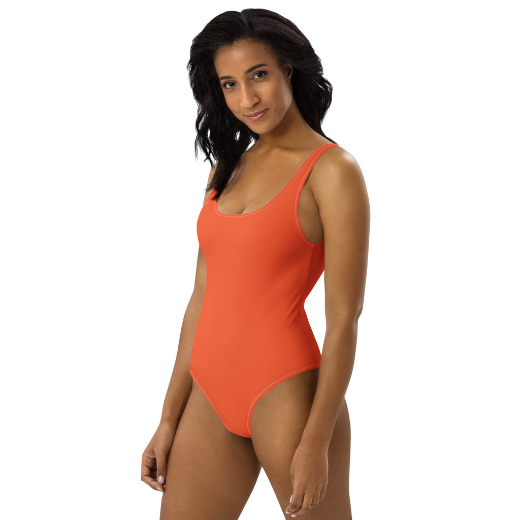 A vibrant orange one-piece buttery soft swimsuit with thin straps and UPF 50 plus sun protection for women