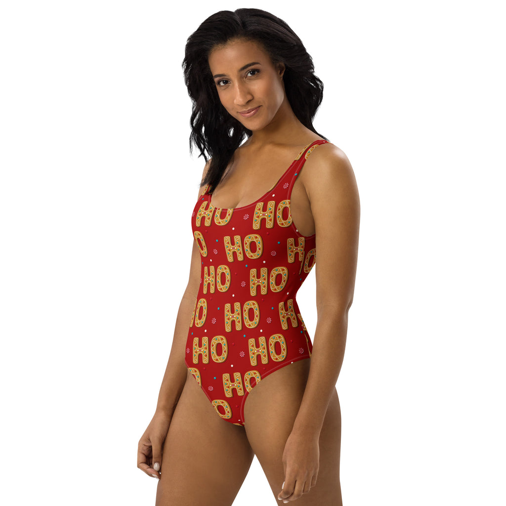 Red one-piece buttery soft swimsuit with festive gold ho ho pattern and snowflake accents with upf 50 plus protection