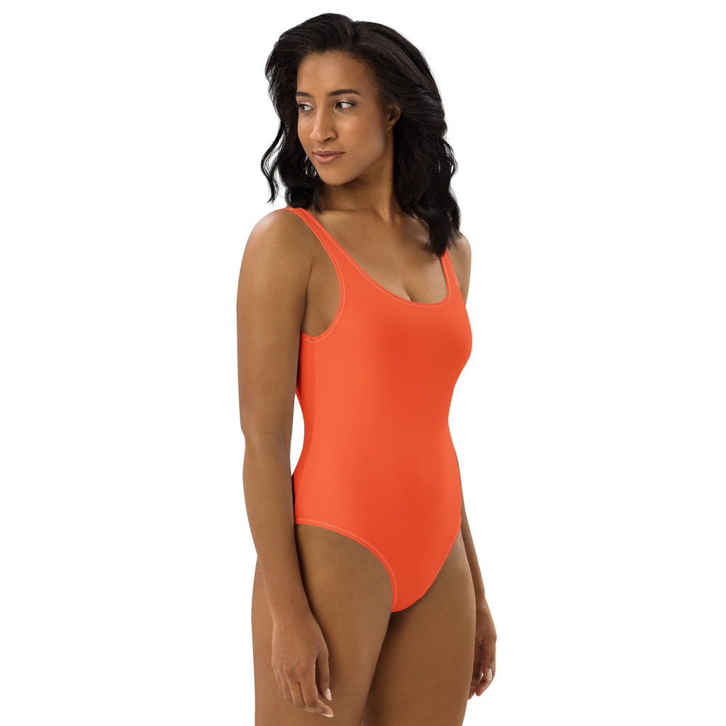 A vibrant orange buttery soft women’s one-piece swimsuit with thin straps scoop neckline and UPF 50 plus protection