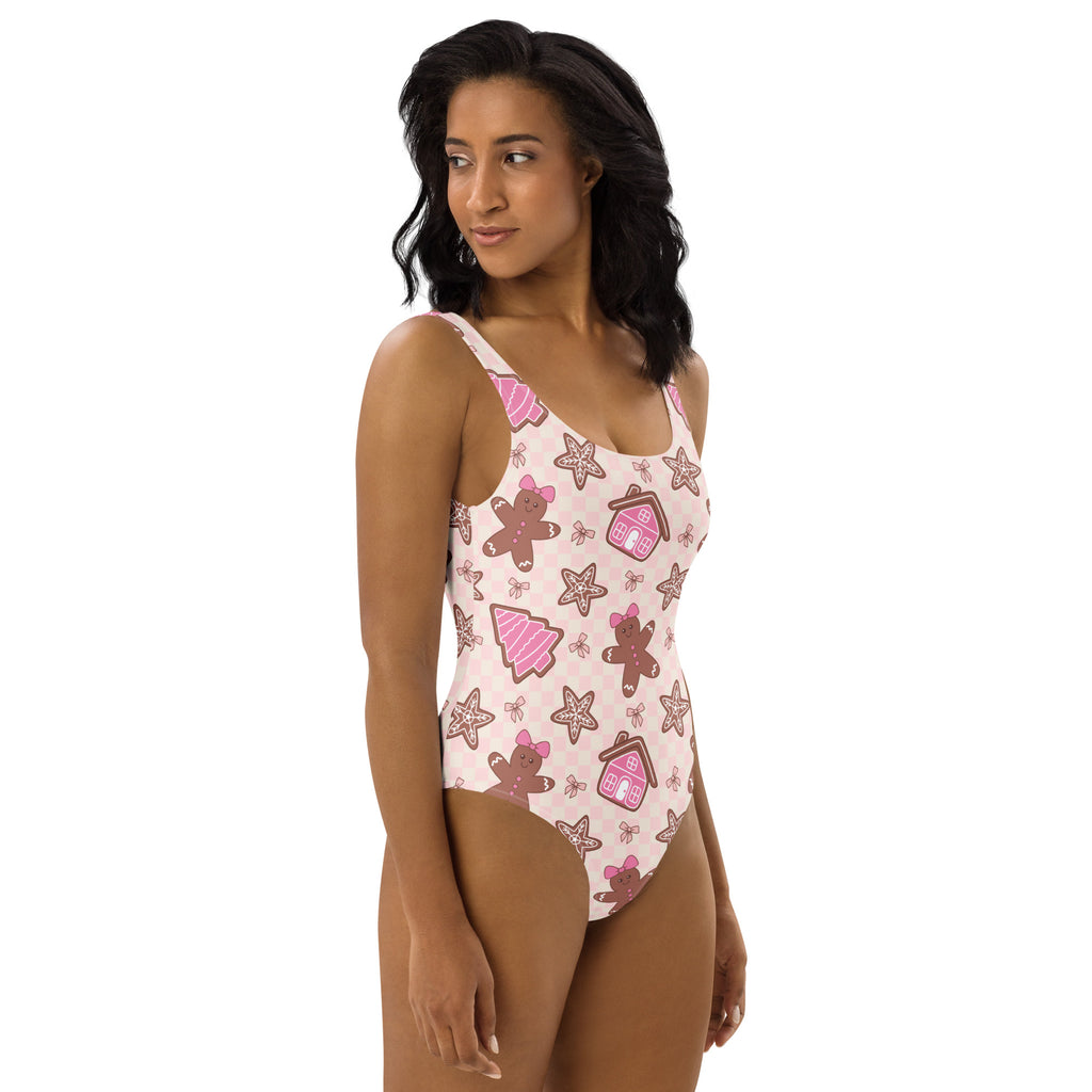 Women’s pink gingerbread christmas buttery soft one-piece swimsuit with festive cookie pattern and upf 50+ protection