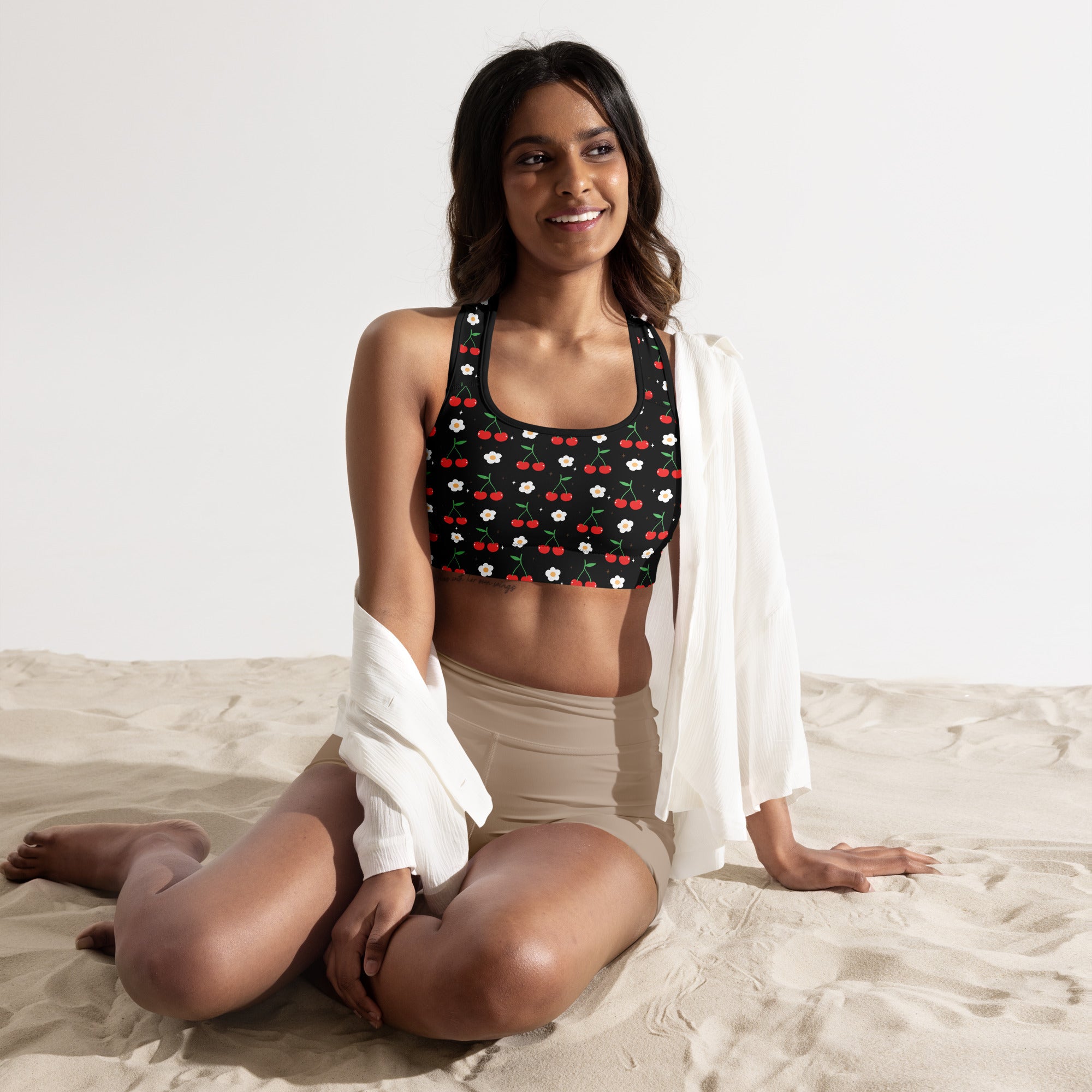 Women’s black padded sports bra with red cherry and white flower pattern made of buttery soft quick-dry fabric