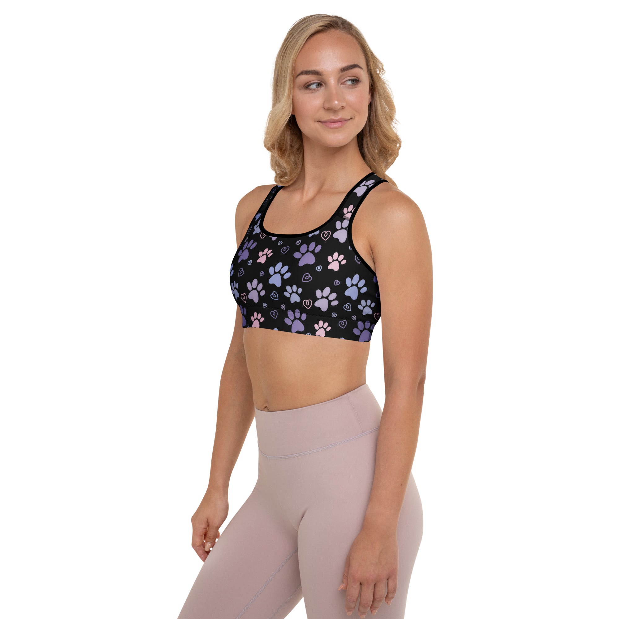 Black women’s padded sports bra with pastel purple and pink paw prints and hearts, buttery soft and quick-dry fabric