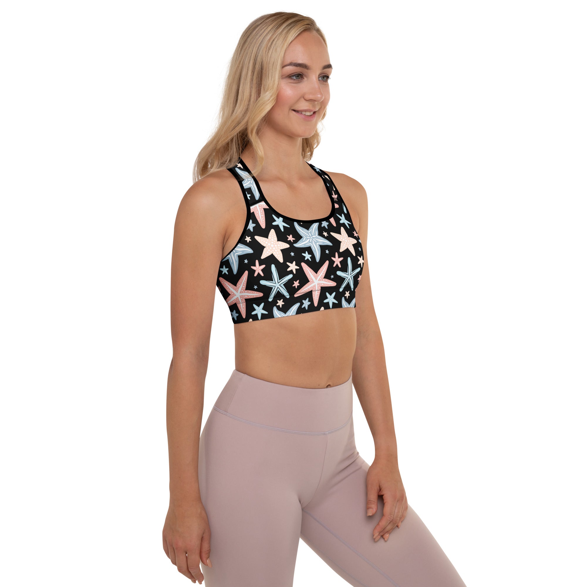 Black women’s padded sports bra with pastel starfish print, buttery soft, supportive, and quick-dry material