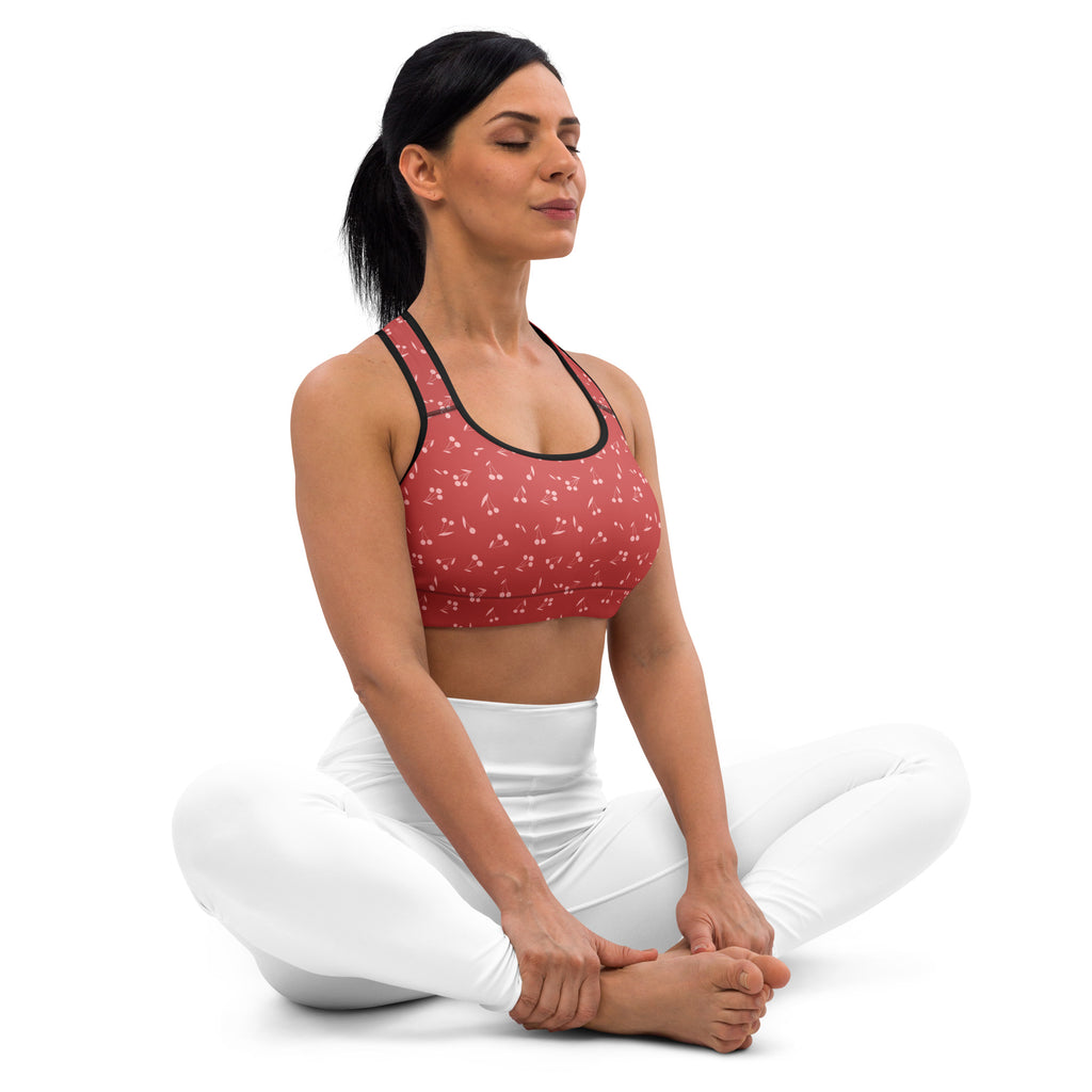 Women’s cherry print padded sports bra in red with black trim and white pattern, buttery soft, supportive, and quick-dry
