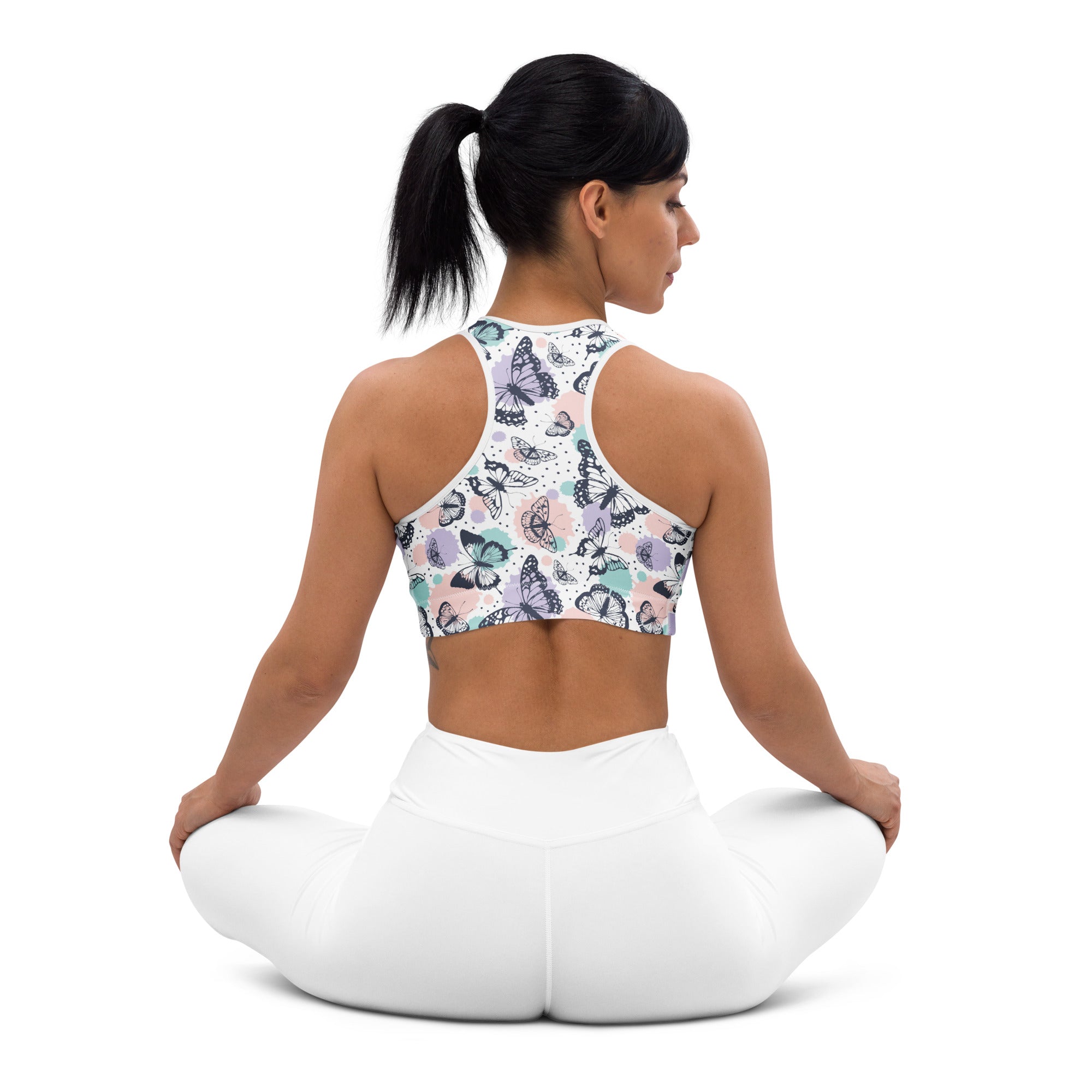 White butterfly patterned women’s padded sports bra with pastel accents buttery soft supportive and quick dry material