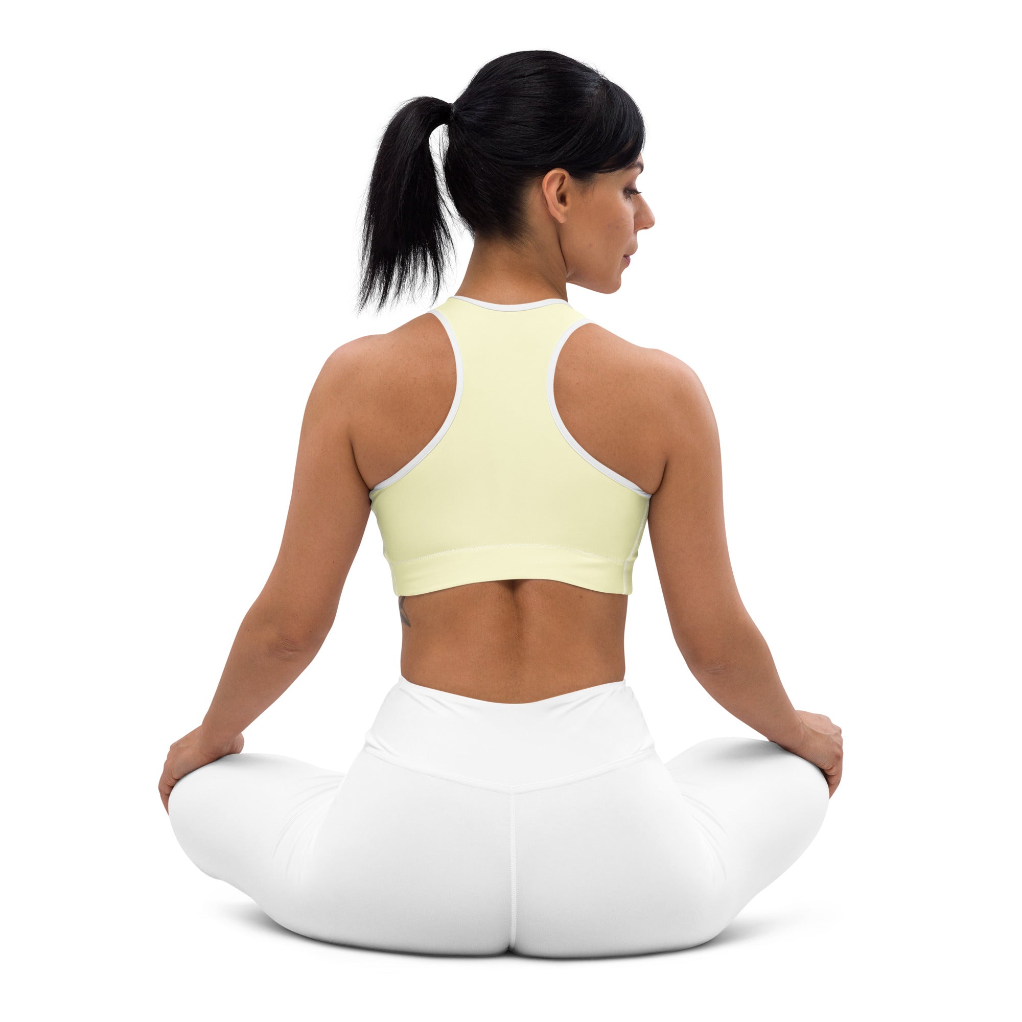 A pale yellow high neck padded sports bra with white trim buttery soft supportive and quick dry for women