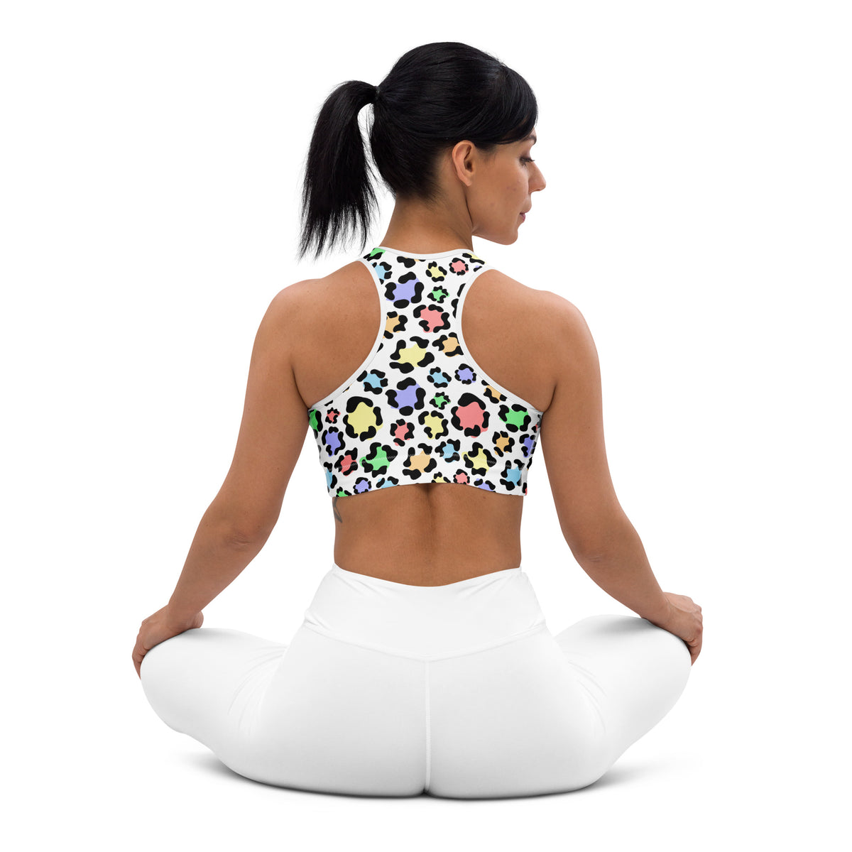 White women’s padded sports bra with colorful pastel leopard print on black outline, buttery soft, supportive, quick-dry