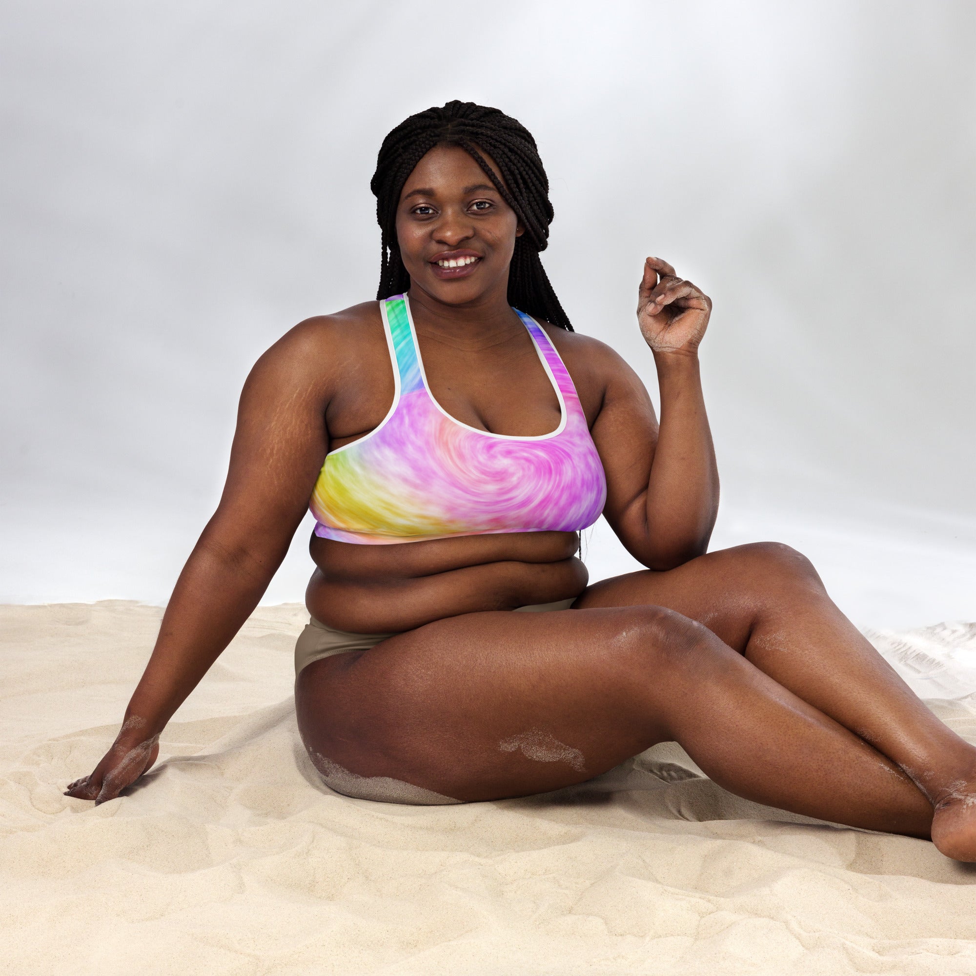 A vibrant tie-dye women’s padded sports bra with pink yellow and blue swirls buttery soft supportive and quick-dry