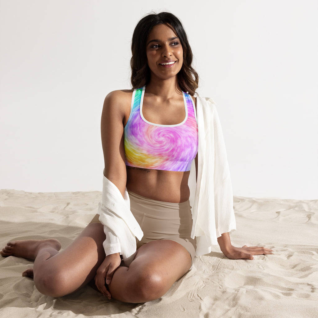 A vibrant womens rainbow tie dye padded sports bra with swirling pink purple yellow and blue in buttery soft quick-dry fabric