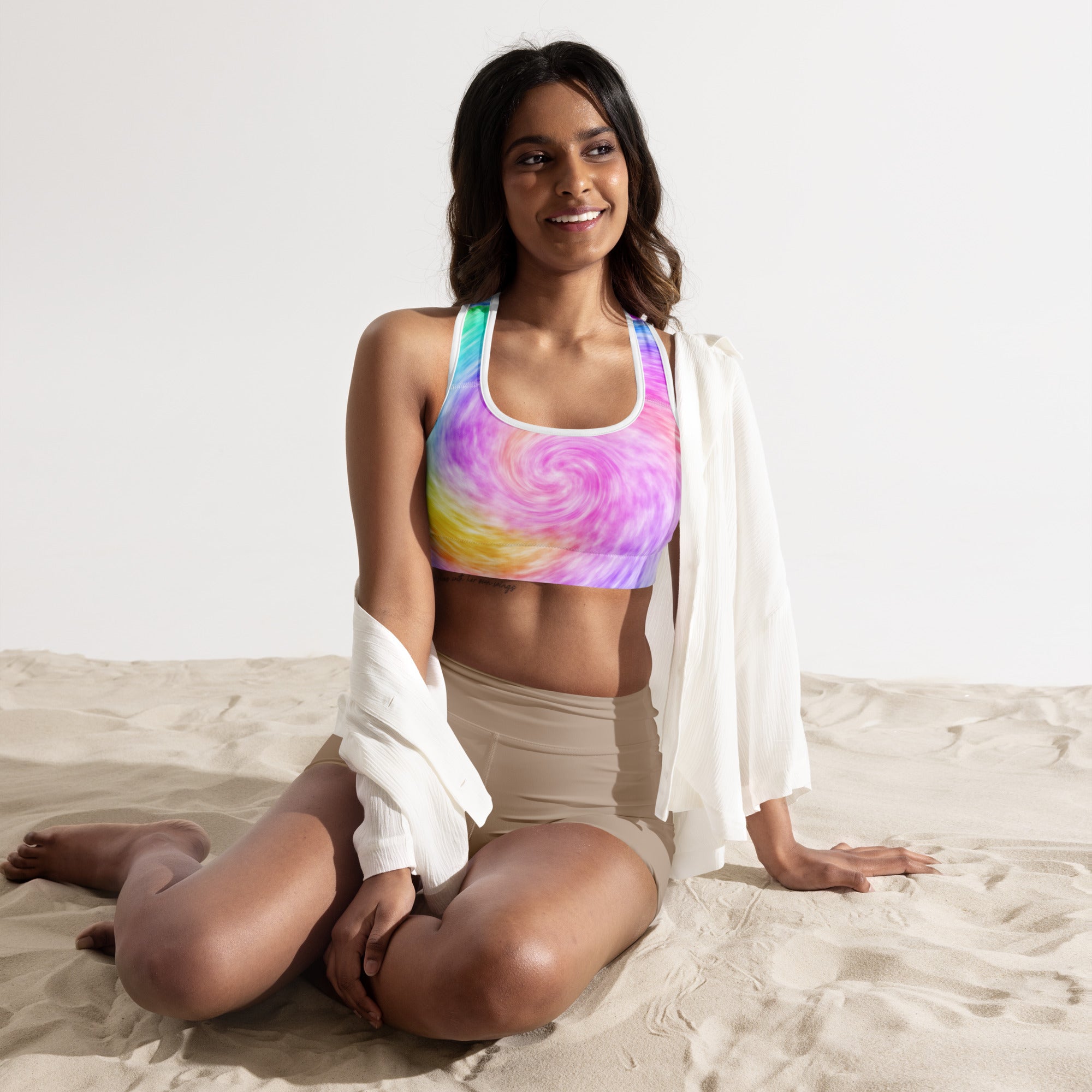 A vibrant womens rainbow tie dye padded sports bra with swirling pink purple yellow and blue in buttery soft quick-dry fabric