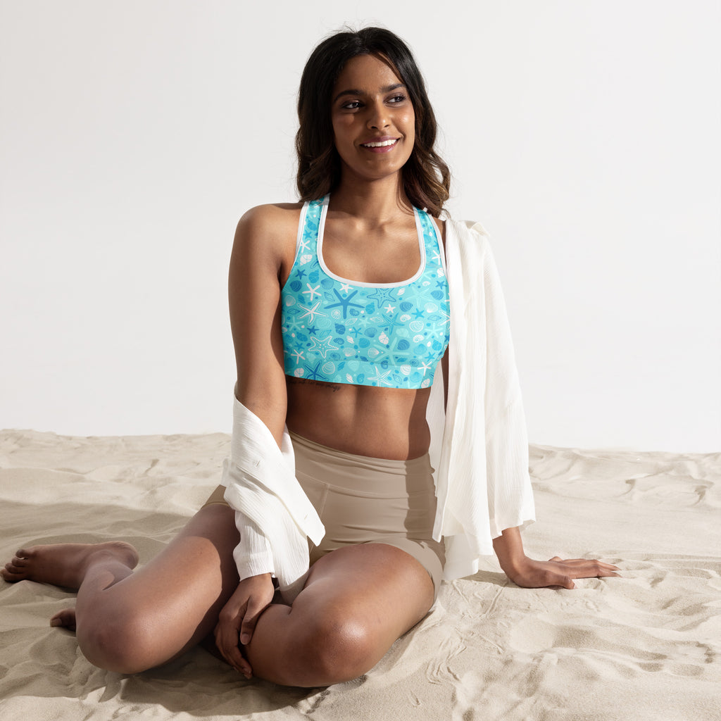 Turquoise padded sports bra with starfish and shell pattern, supportive straps, scoop neckline, buttery soft and quick-dry