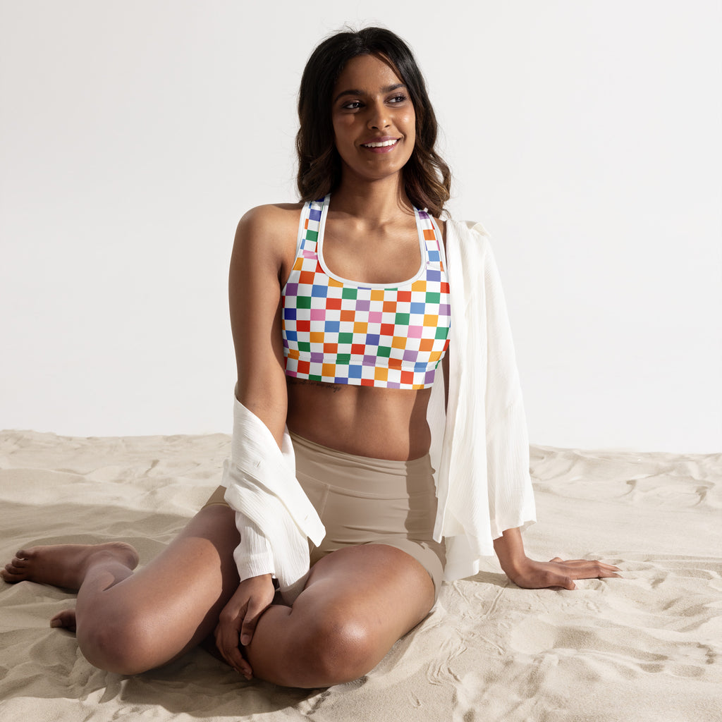 A vibrant rainbow checkered padded sports bra with halter neckline, buttery soft fabric, supportive and quick-dry design