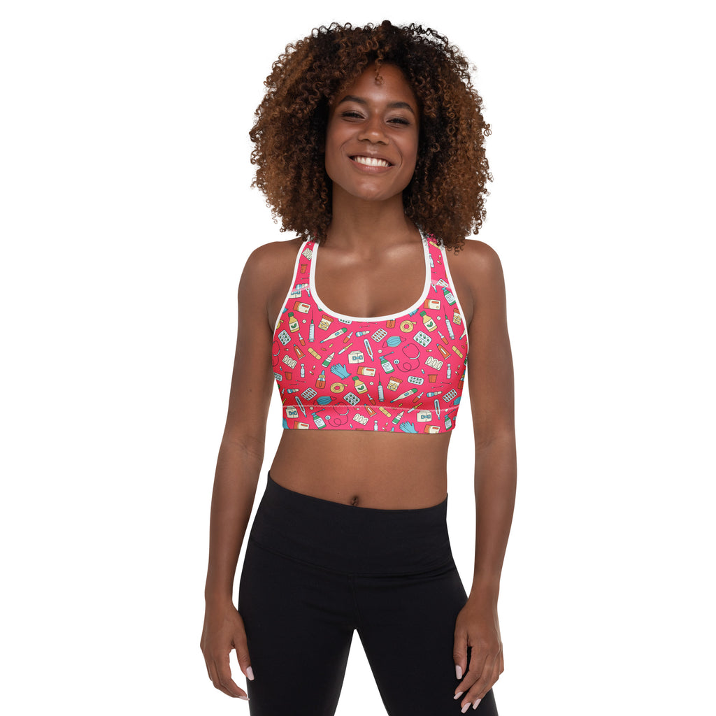 Women’s nurse padded sports bra in pink with white trim featuring a playful pastel medical icon pattern