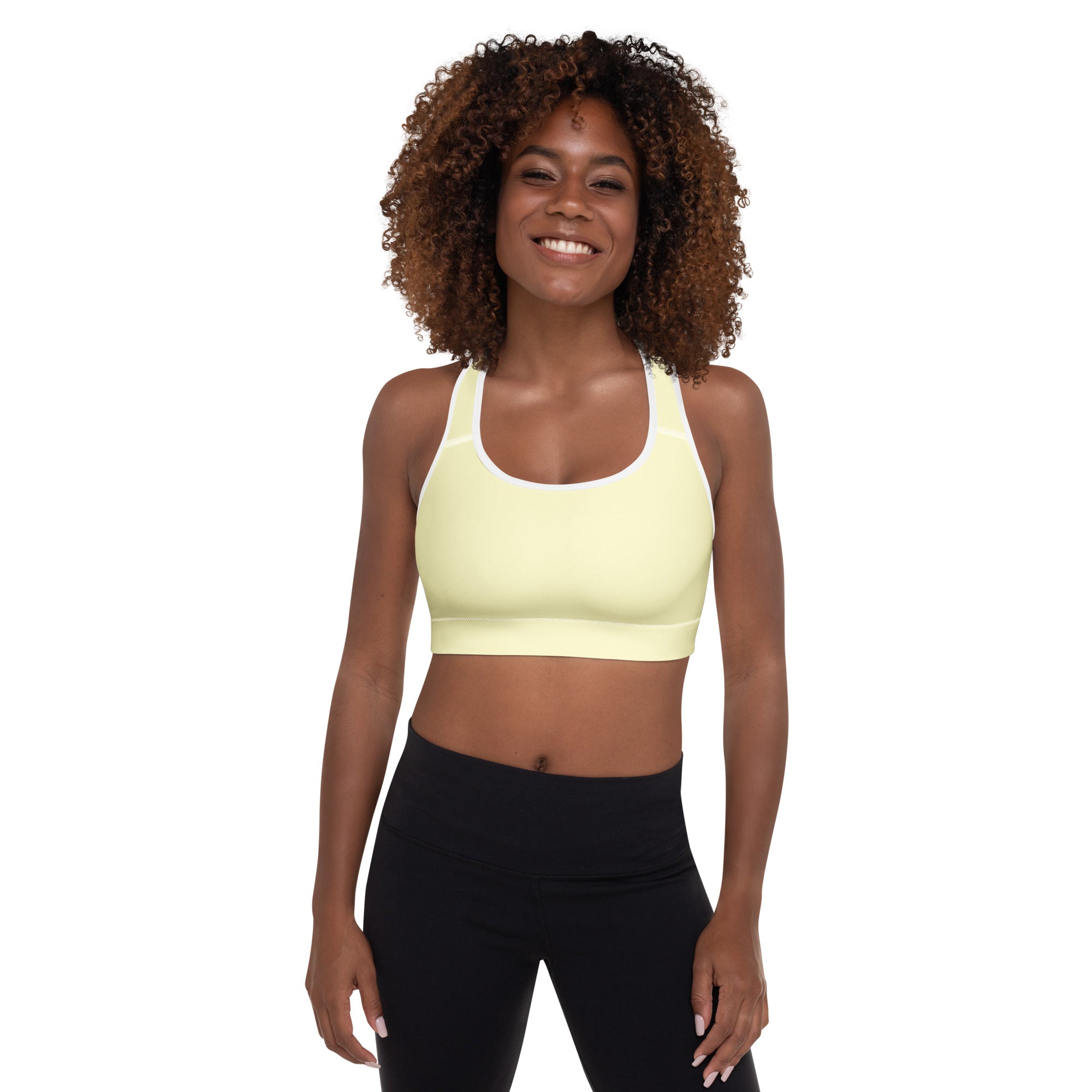 A pale yellow women’s sports bra with white trim featuring a seamless, padded, supportive, and quick-dry design