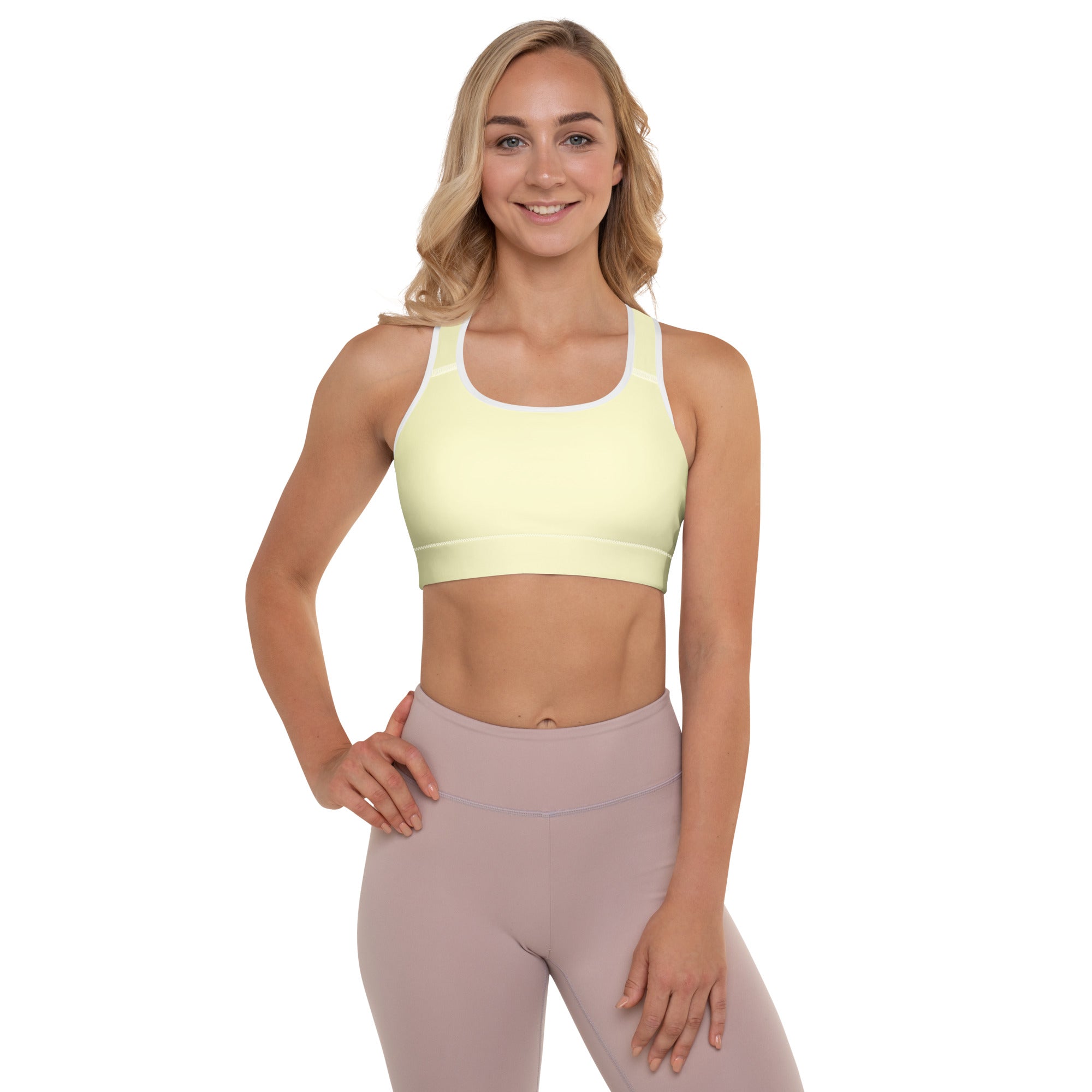 A pale yellow padded sports bra with white trim and racerback design offering buttery soft quick-dry support