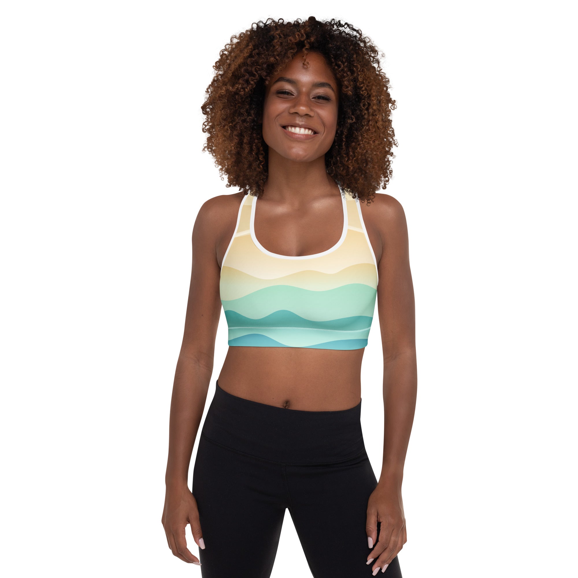 A woman wearing a vibrant pastel ocean wave padded sports bra in yellow and teal with quick-dry buttery soft fabric