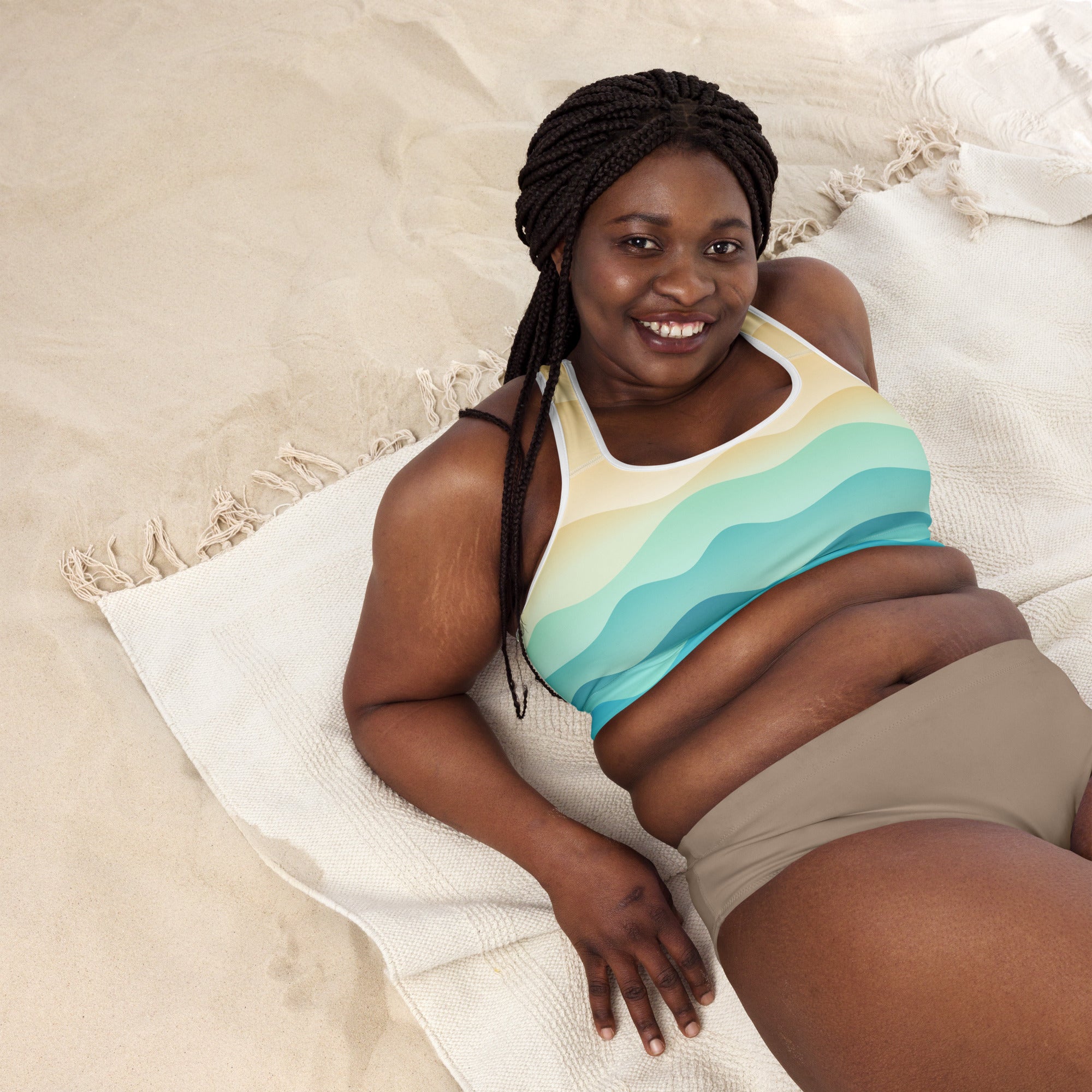 A woman wearing a pastel ocean wave padded sports bra with colorful wavy stripes in yellow and teal