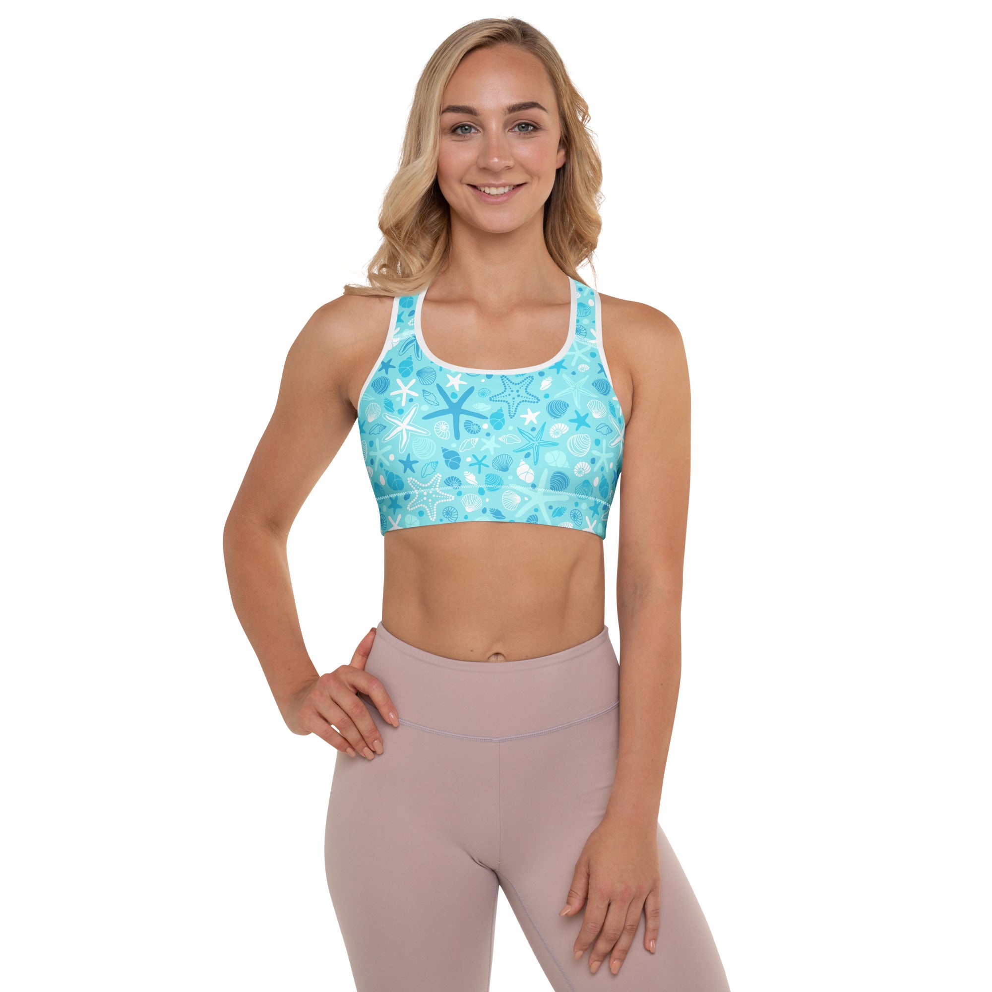 Women’s turquoise padded sports bra with white trim and ocean-themed starfish and shells pattern, buttery soft and quick-dry