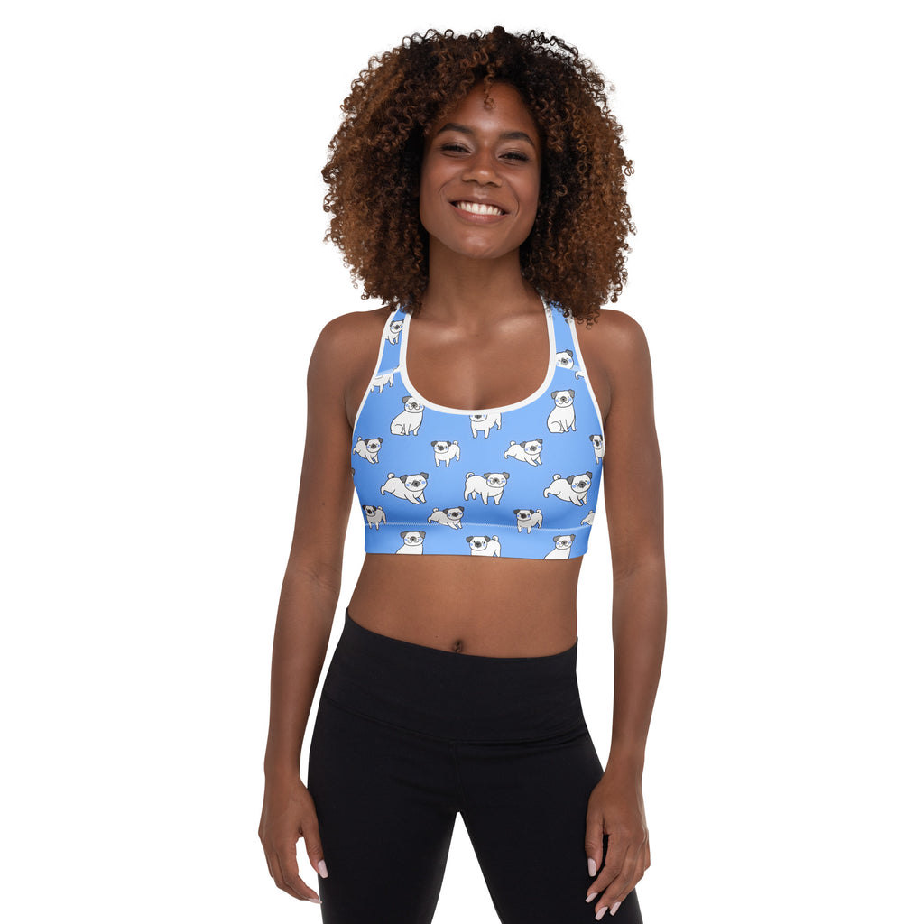 Women’s blue padded sports bra with white pug illustrations and white trim, buttery soft, supportive, and quick-dry