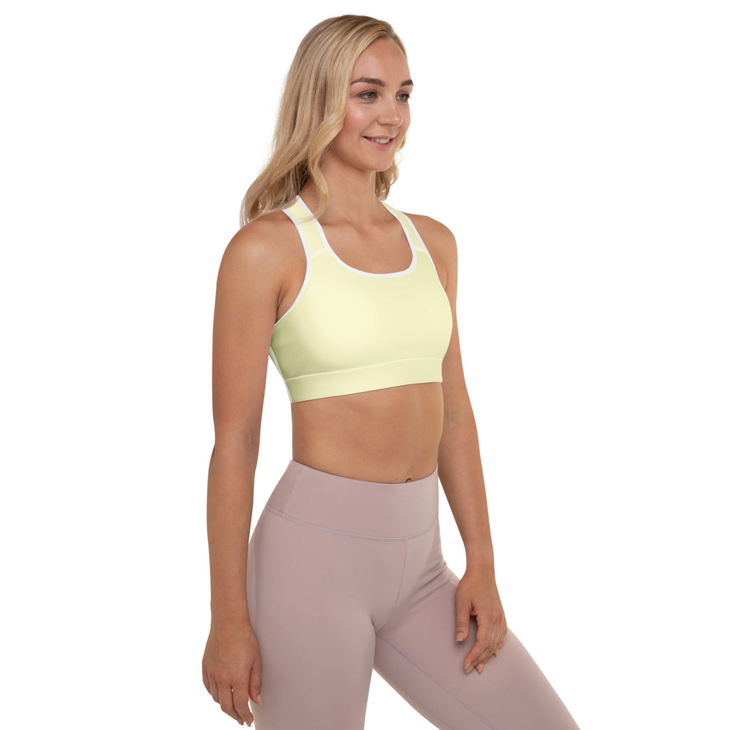 Light yellow padded sports bra with white trim and racerback design made from buttery soft quick-dry fabric