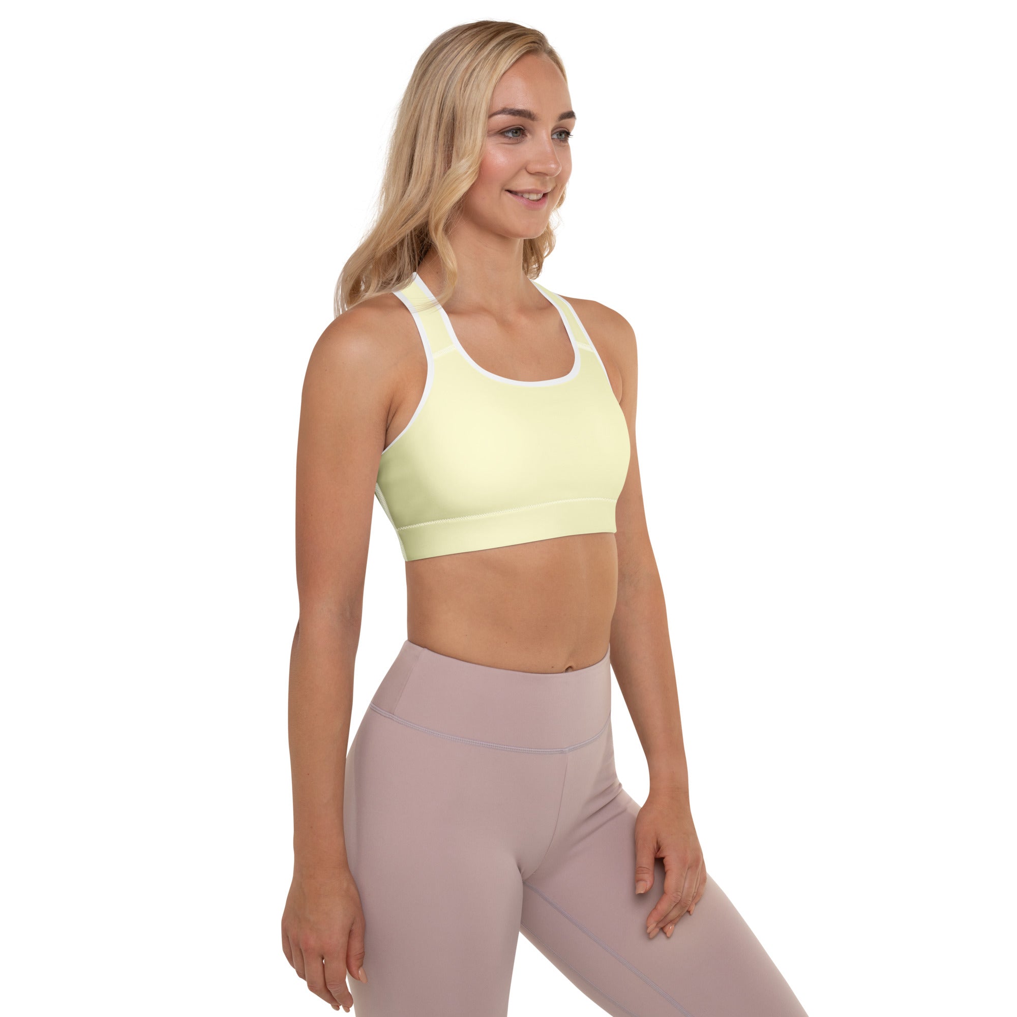 Light yellow padded sports bra with white trim and racerback design made from buttery soft quick-dry fabric