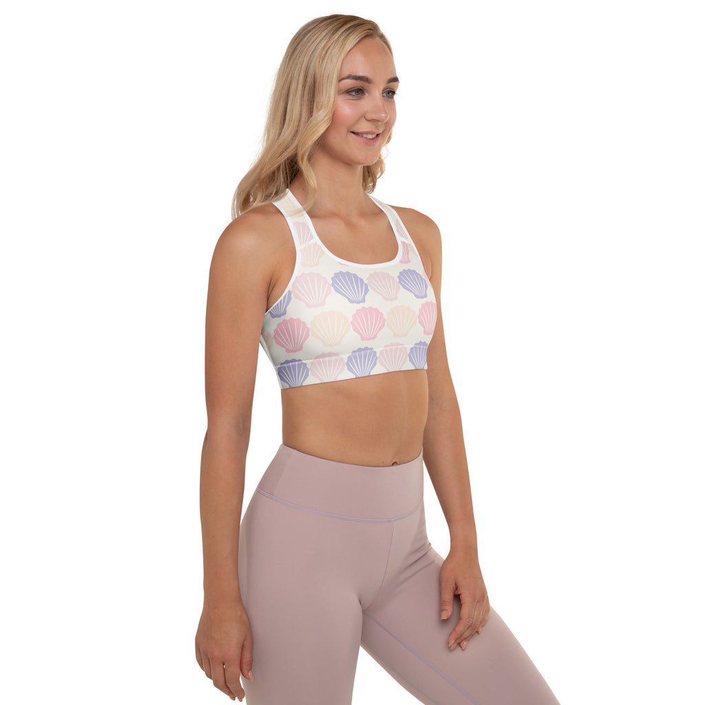 A white pastel seashell padded sports bra with buttery soft fabric offering support and quick-dry comfort