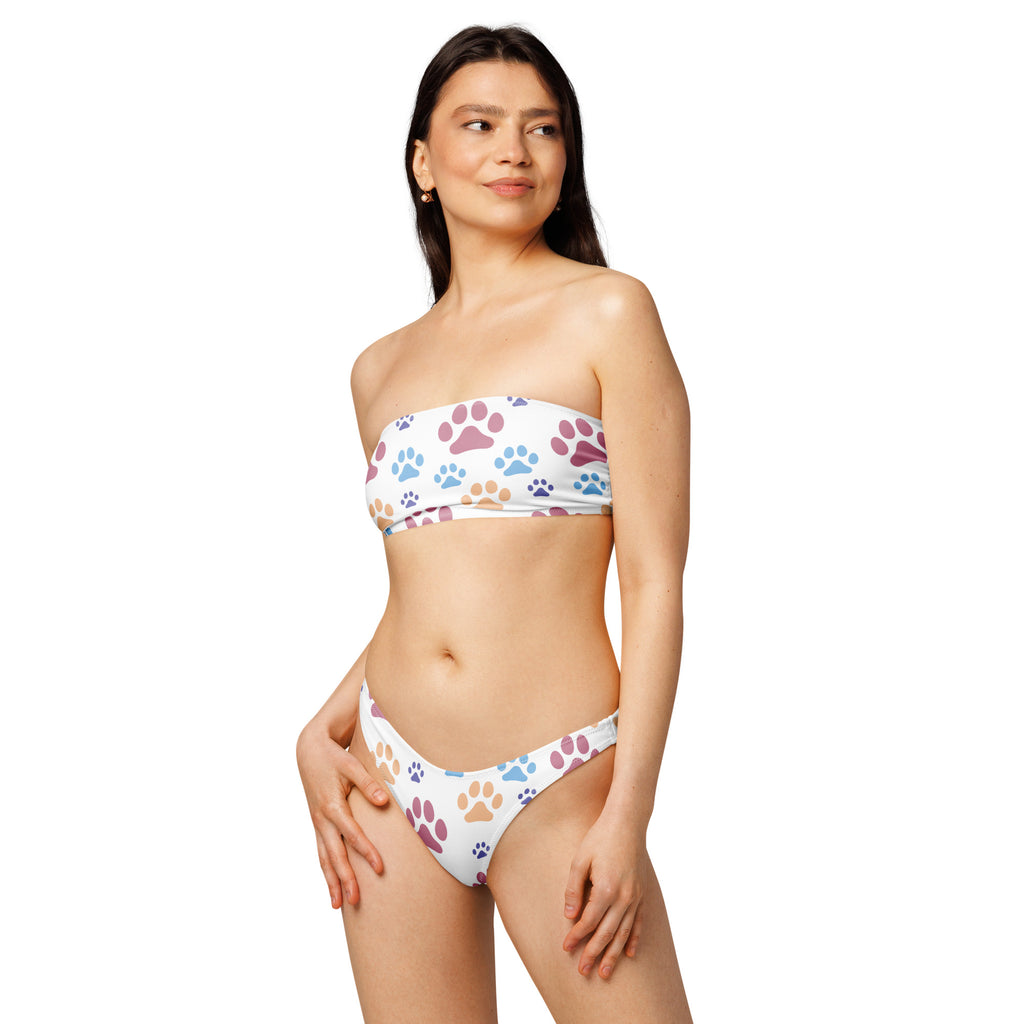 White strapless bikini set with colorful purple blue and tan paw prints made of recycled quick drying fabric with upf 50+