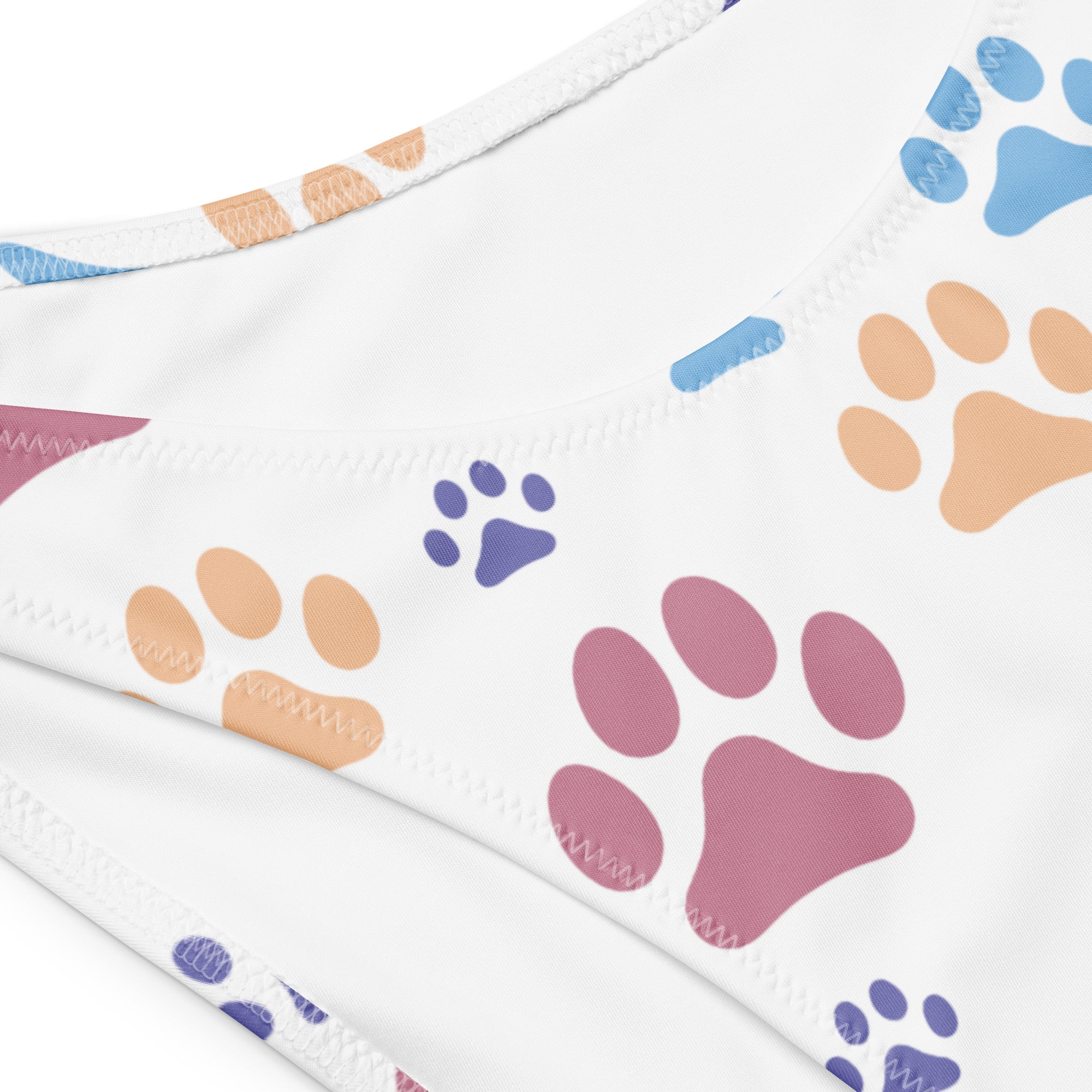 White bandeau bikini top with colorful blue pink and orange paw prints made from quick drying recycled fabric with UPF 50+