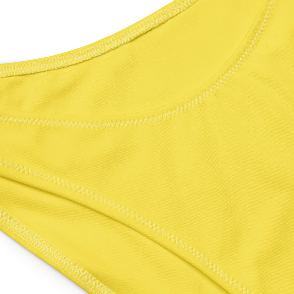 Bright yellow stretchy recycled fabric with neat stitching on a women’s yellow recycled bandeau bikini with upf 50+