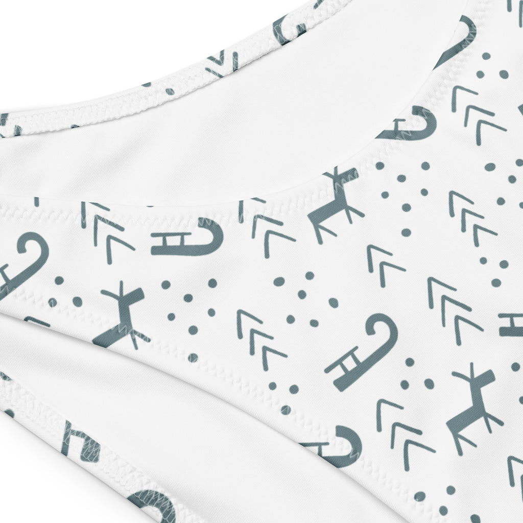 White bikini bottom with gray reindeer candy cane and arrow pattern in quick drying recycled fabric with upf 50+