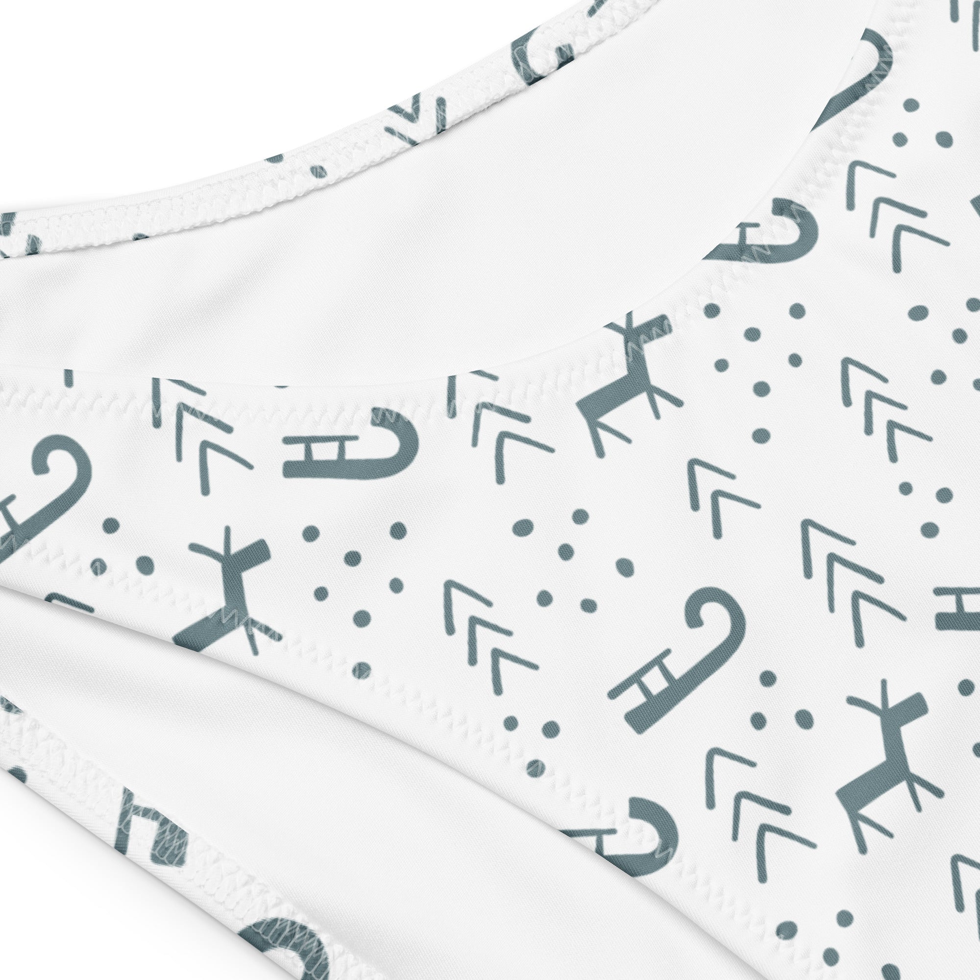White bikini bottom with gray reindeer candy cane and arrow pattern in quick drying recycled fabric with upf 50+
