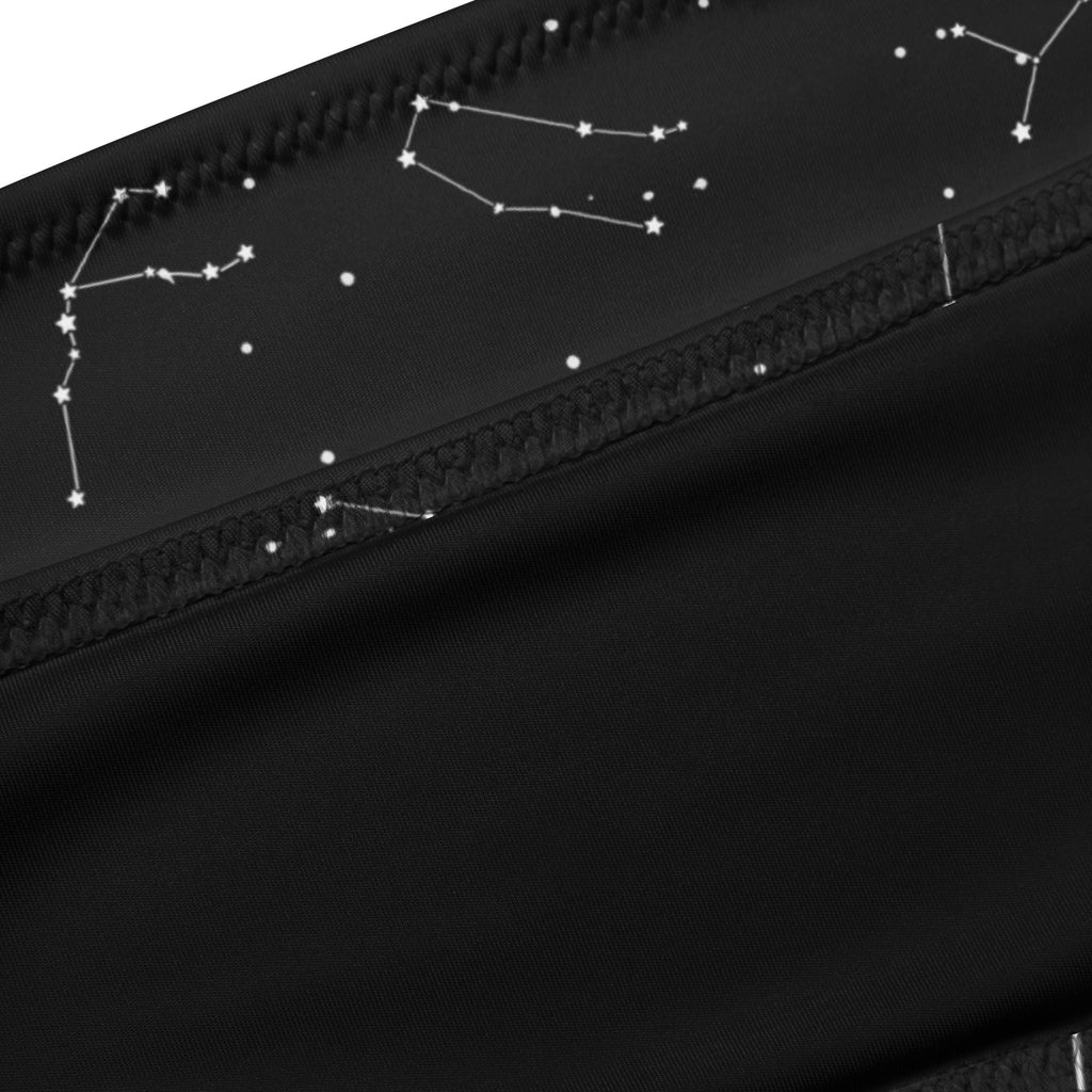 Black fabric pouch with white embroidered constellations along zipper line complementing women’s constellation bandeau bikini
