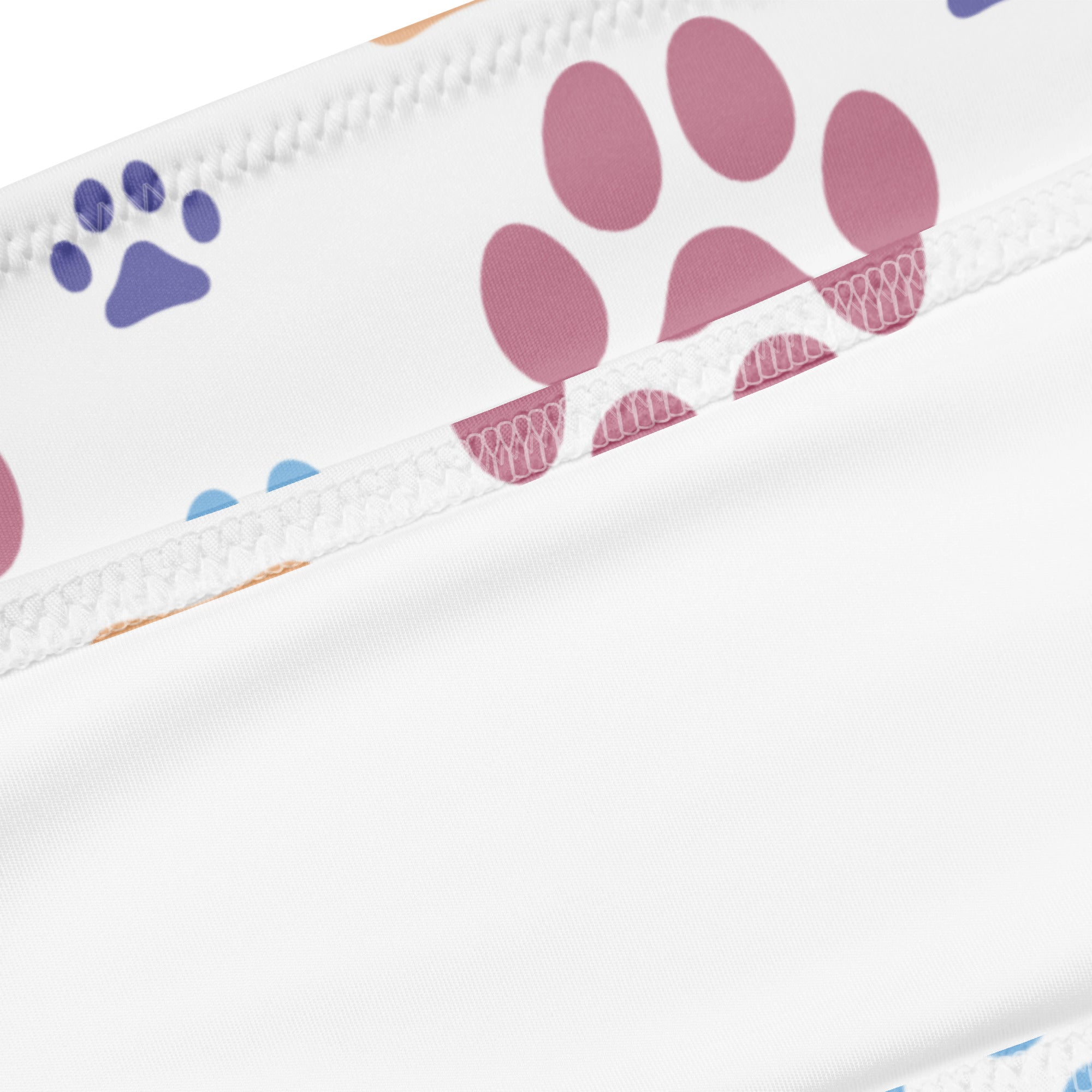 White fabric with pink and purple paw prints along zipper edge on women’s colorful paw prints recycled bandeau bikini with upf 50+