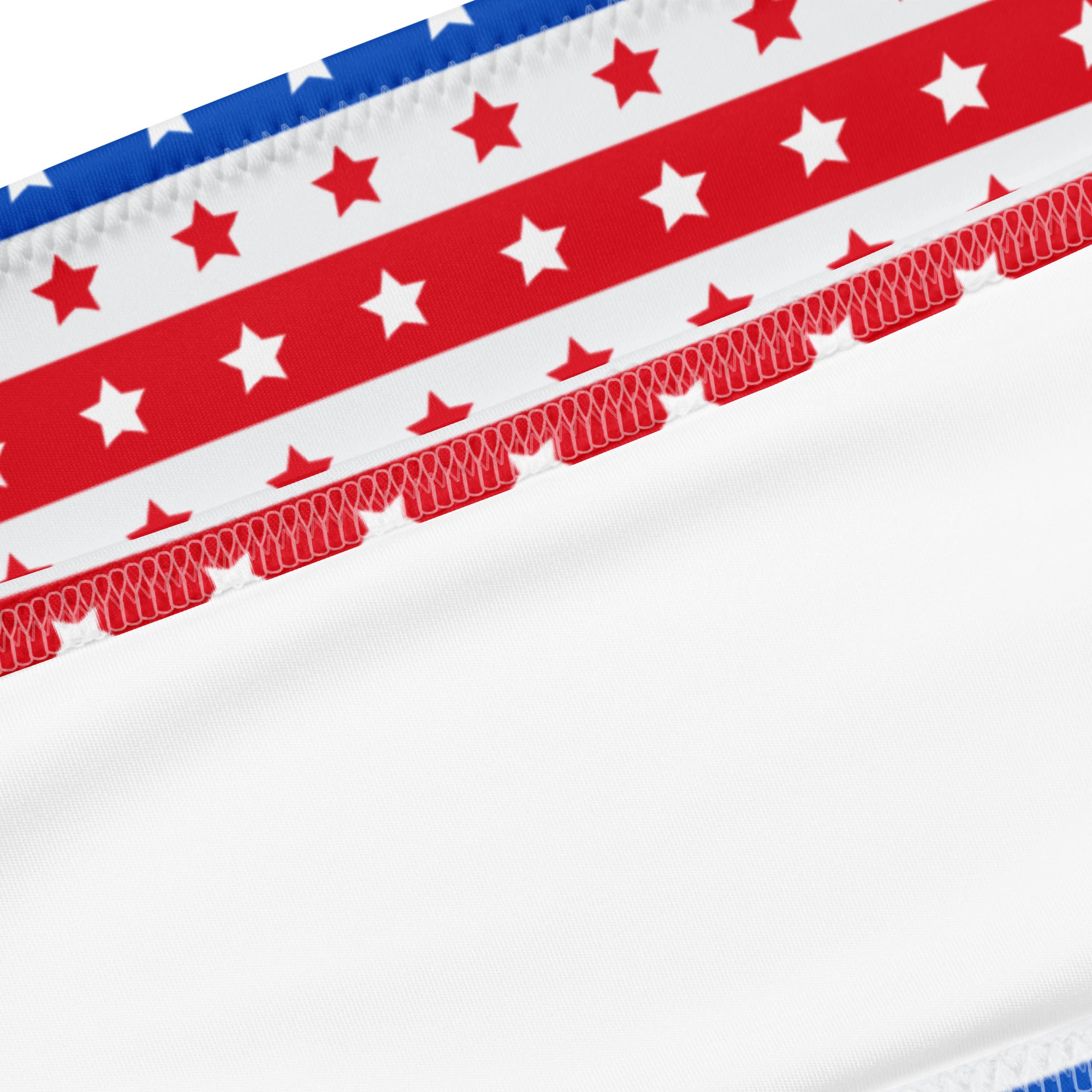 White fabric with red and blue stripes and stars on a women’s recycled quick drying bandeau bikini with stitched edge
