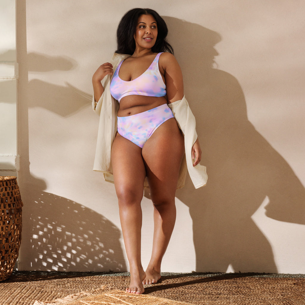 Woman in a colorful bikini standing against a beige wall with a woven basket on the floor.