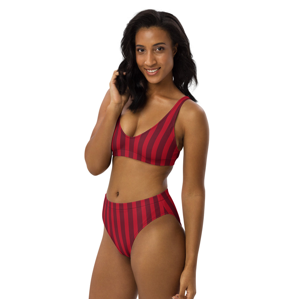A woman wearing a women’s deep red stripe recycled bikini with bold red and black vertical stripes and upf 50+ fabric