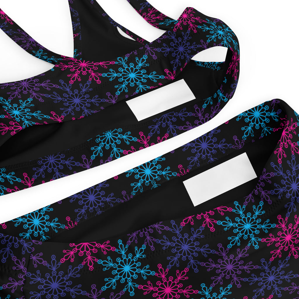 Women’s black sports bra with neon pink blue purple snowflake pattern made from quick drying recycled fabric with upf 50+