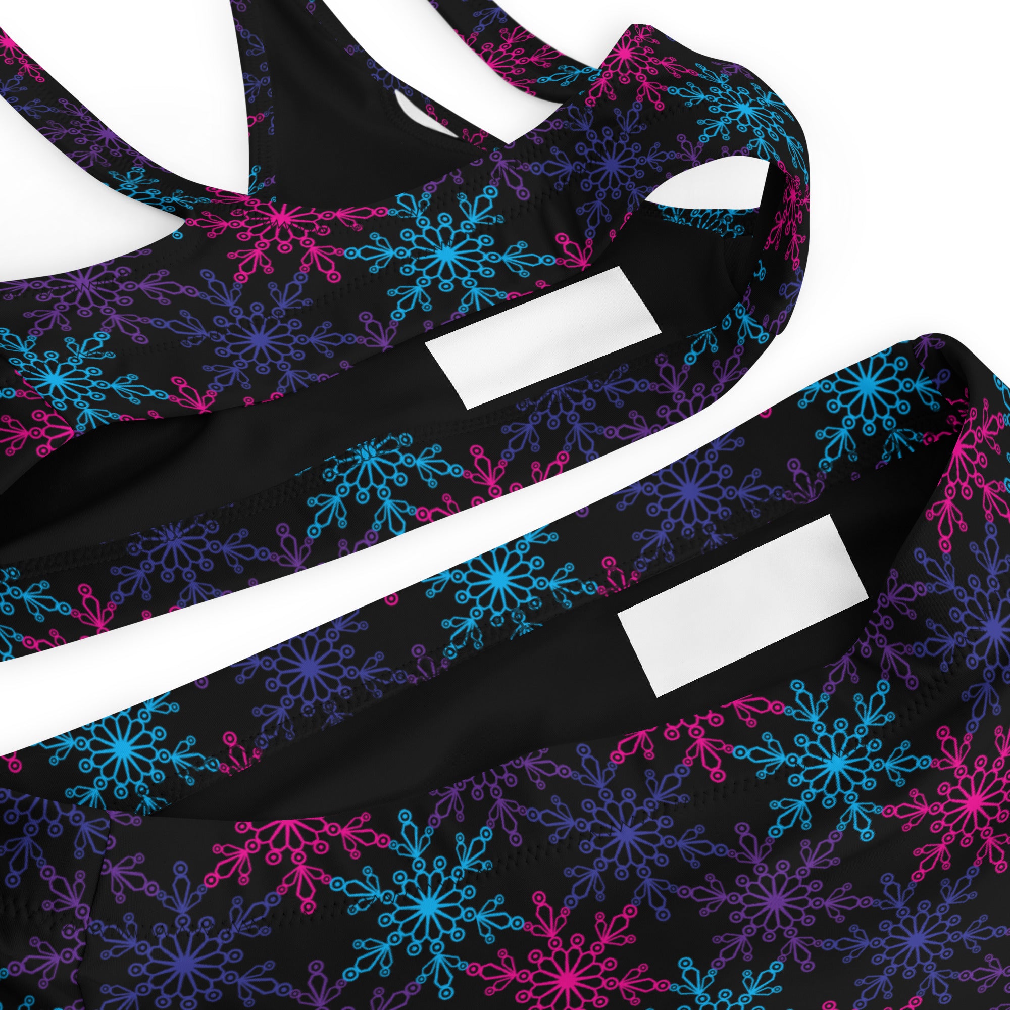 Women’s black sports bra with neon pink blue purple snowflake pattern made from quick drying recycled fabric with upf 50+