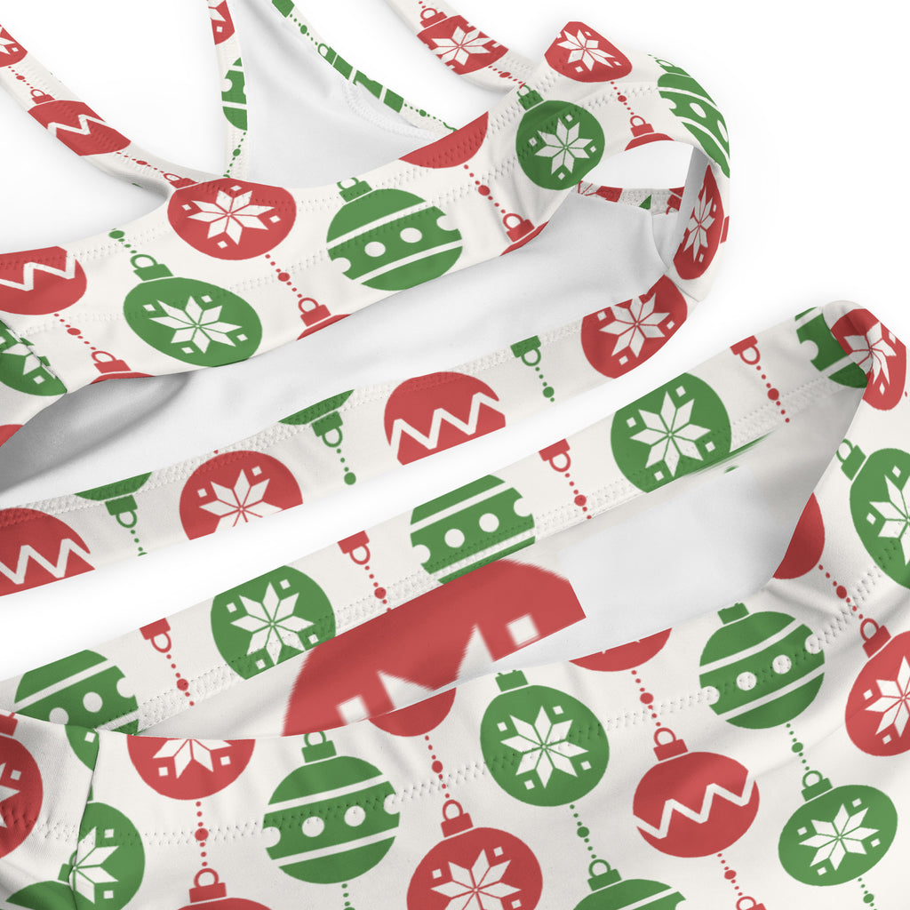 White bikini top with festive red and green christmas ornament pattern and snowflakes made from quick drying recycled fabric with upf 50+