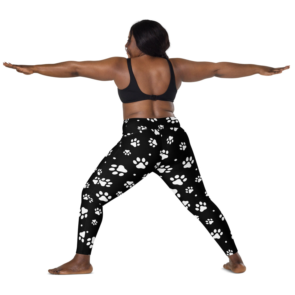 Black women’s high-waisted yoga leggings with soft compression fabric and white paw print pattern with pockets