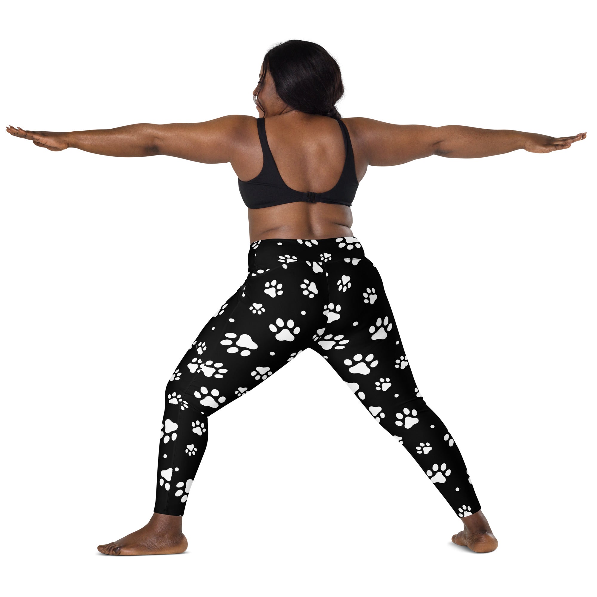 Black women’s high-waisted yoga leggings with soft compression fabric and white paw print pattern with pockets