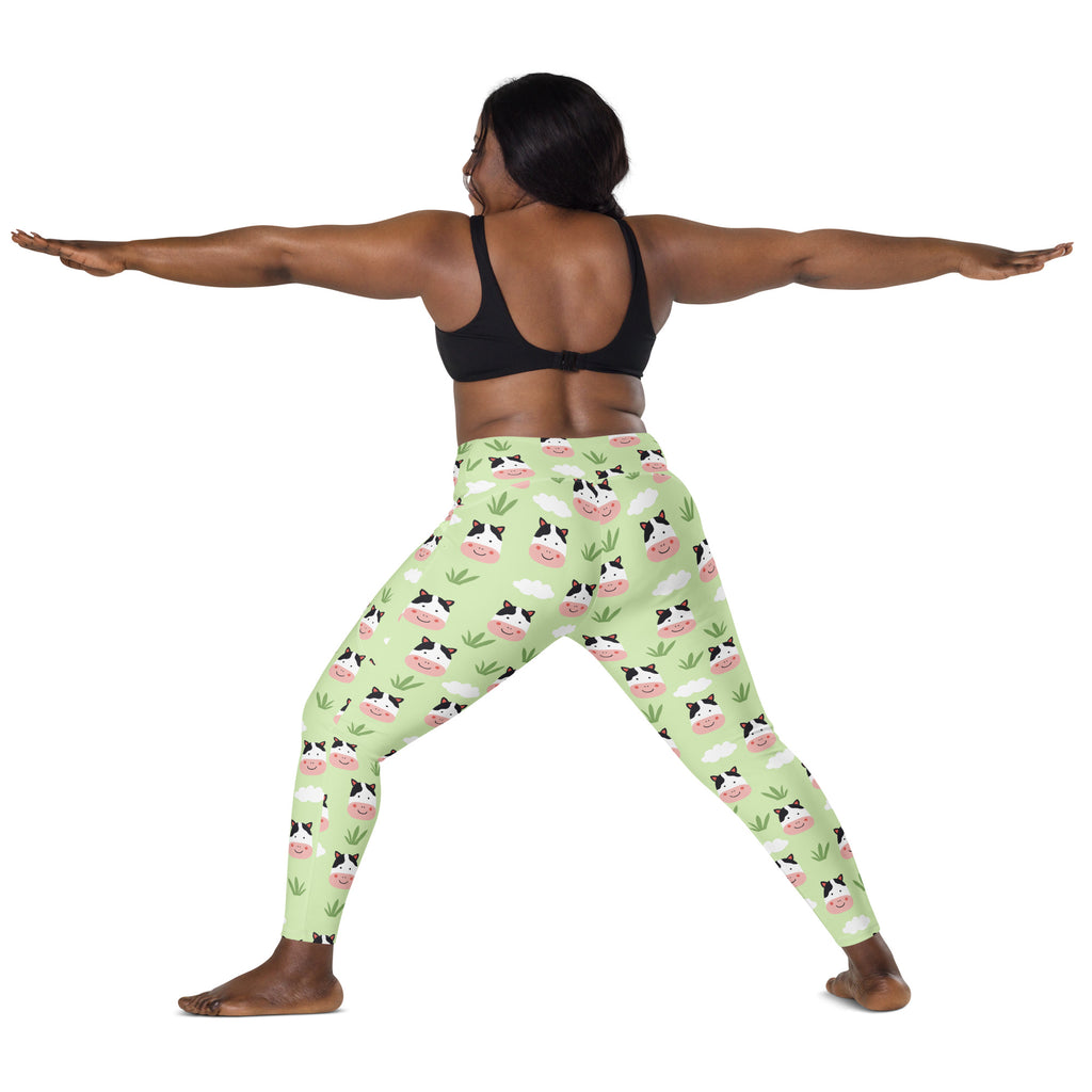 Light green high-waisted women’s yoga leggings with soft compression featuring cartoon cow faces and grass pattern
